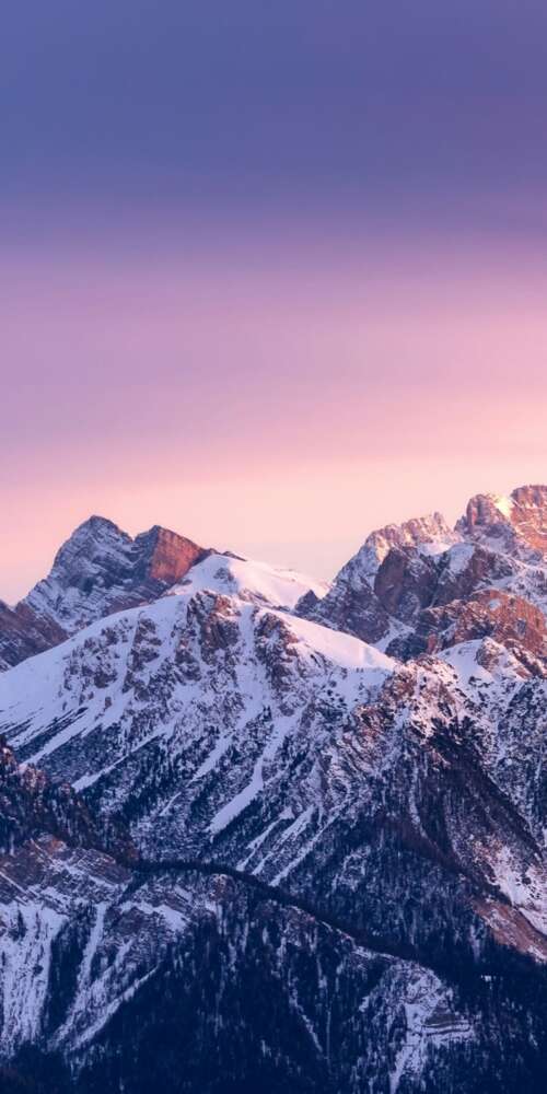Sunset over snow-capped mountain peaks with a colorful gradient sky wallpaper
