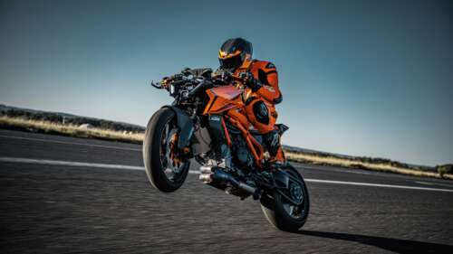 A biker riding a 2024 KTM 1390 Super Duke R through a turn on a professional racing... wallpaper