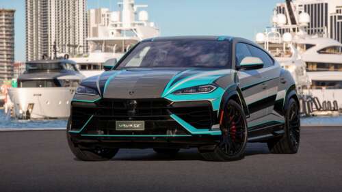 A luxury Lamborghini Urus SE plug-in hybrid SUV driving through the bright, sunny... wallpaper