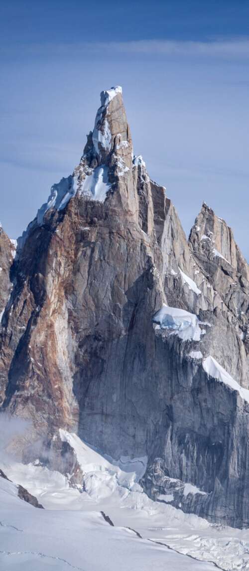 Snow-covered peaks of Cerro Torre and Fitz Roy in the Patagonian Andes under a clear... wallpaper