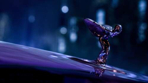 A luxury 2025 Rolls-Royce Black Badge Spectre car featuring a vibrant purple neon... wallpaper