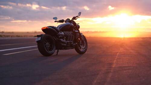 Triumph Rocket 3 GT motorcycle parked during a vibrant sunset wallpaper