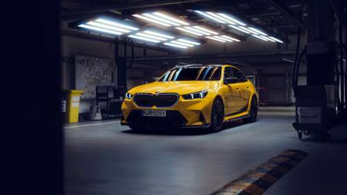 A close-up, high-detail shot of a bright yellow BMW M5 luxury sports sedan. wallpaper
