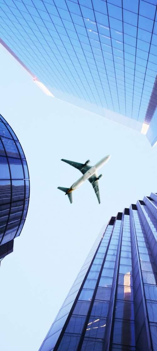 A wide-angle shot of a dense metropolis with massive skyscrapers and an airplane... free wallpaper