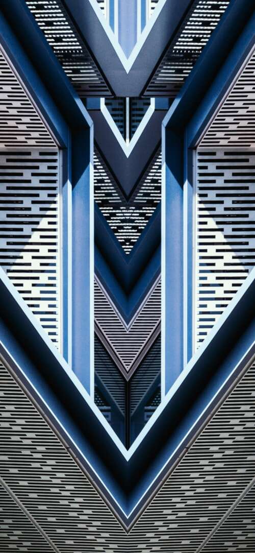 Close-up of a symmetrical blue building with intricate geometric patterns. wallpaper