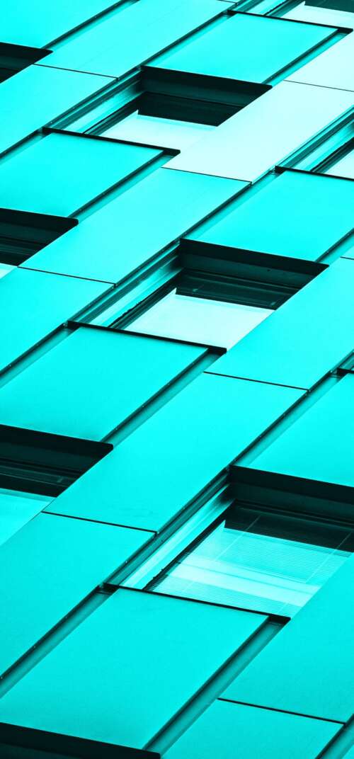 A modern glass office building with a vibrant teal and turquoise color palette under... wallpaper