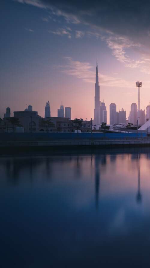 A panoramic view of the Dubai cityscape at sunset with modern skyscrapers and waterfront... download free phone wallpaper