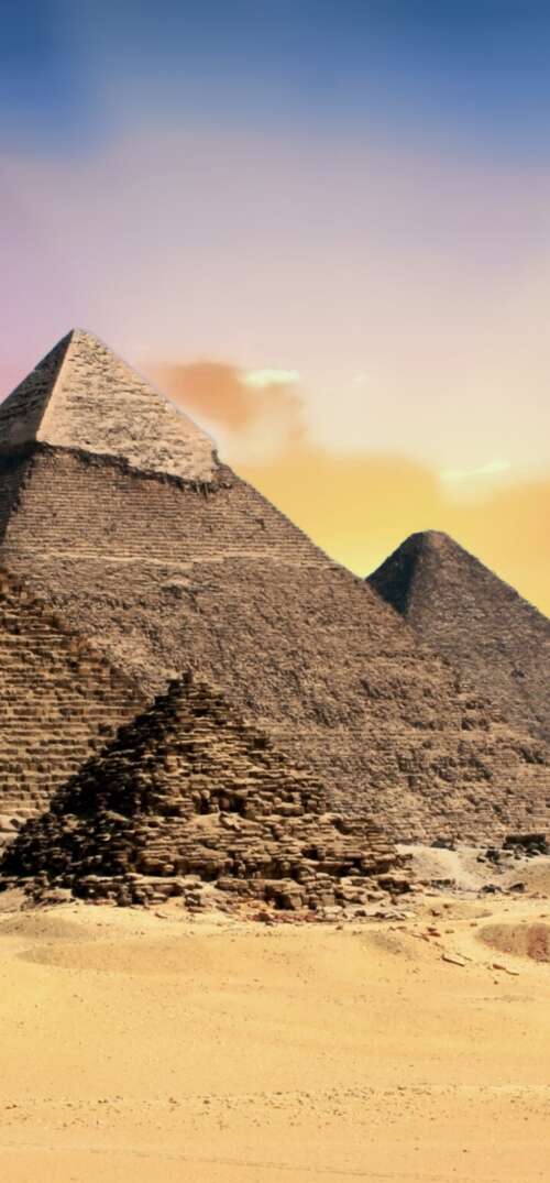 A scenic view of the Egyptian Pyramids during a golden sunset. wallpaper