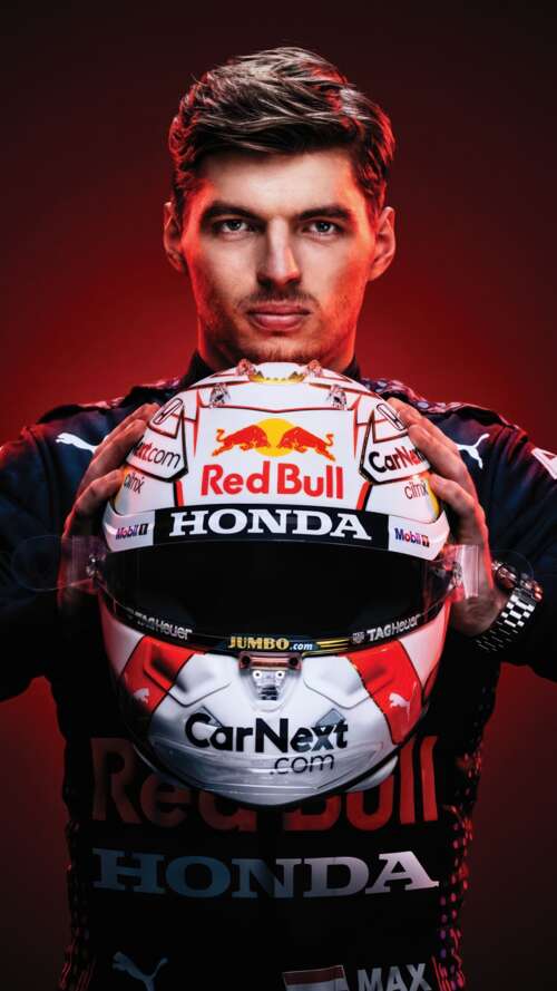 Close-up of Max Verstappen wearing a Red Bull Racing helmet against a dark background.