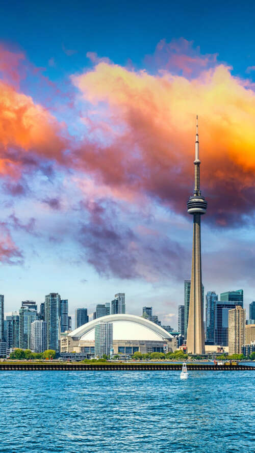 Panoramic view of the Toronto skyline featuring the CN Tower and Lake Ontario under... wallpaper