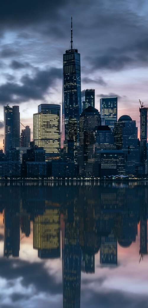 Manhattan skyline at dusk with skyscrapers reflecting in the Hudson River. wallpaper download