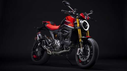 A close-up, dramatic shot of a 2023 Ducati Monster SP motorcycle against a dark,... free wallpaper