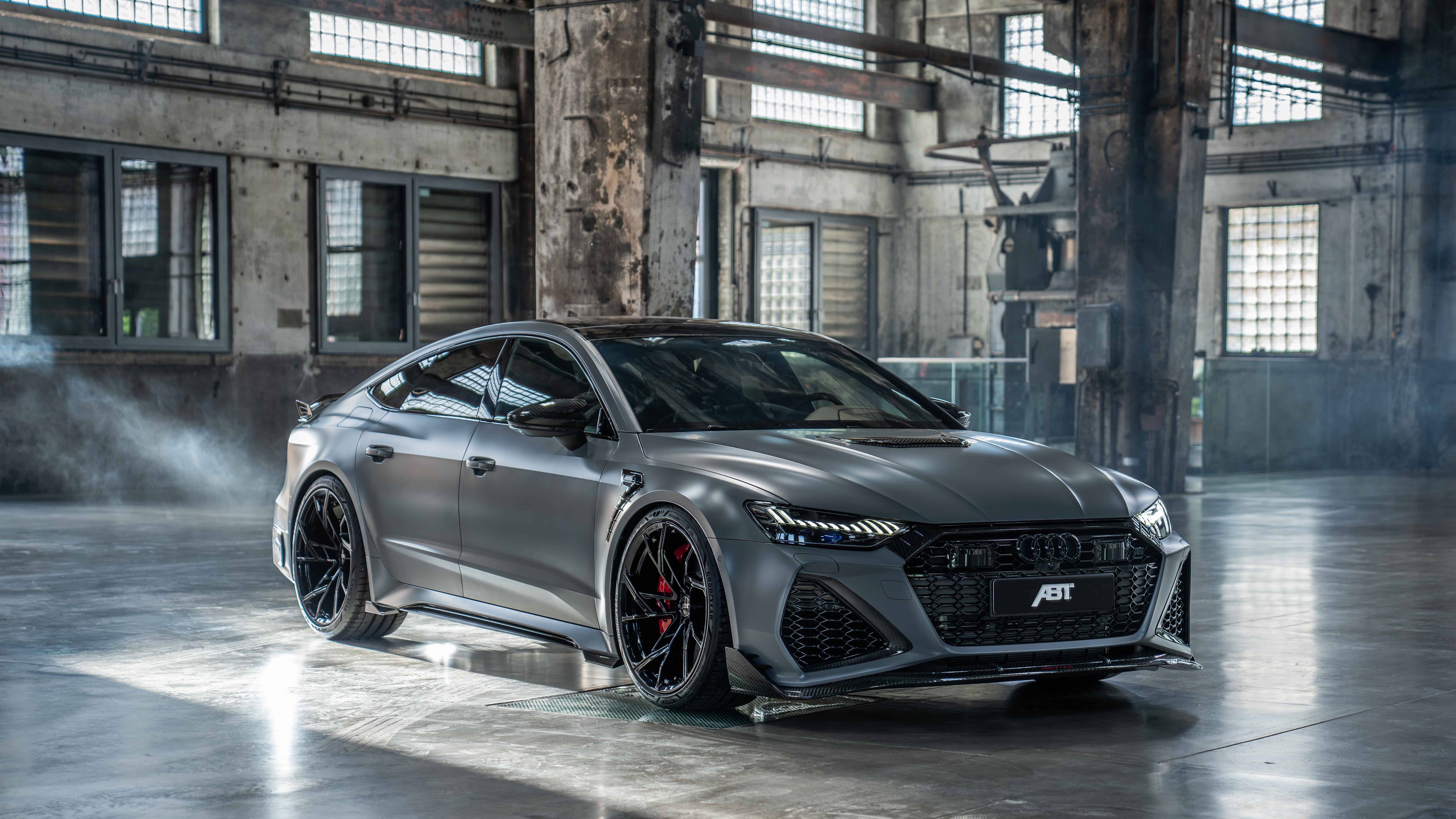 A high-performance Audi RS7 sedan with a sleek, metallic body and aggressive front grille design.
