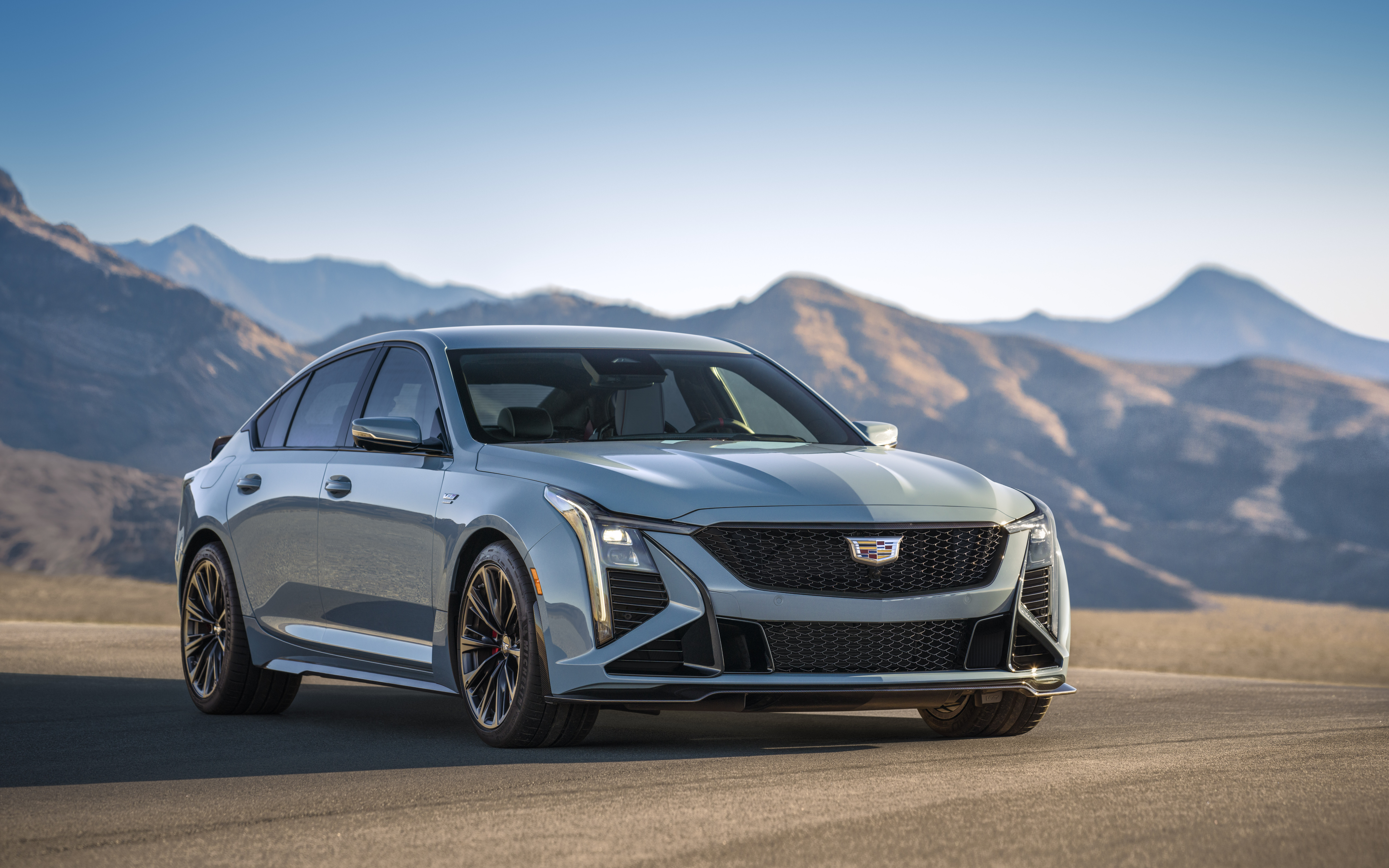 A detailed view of a Cadillac CT5-V Blackwing sedan, emphasizing its modern grille, headlights, and luxury automotive design.