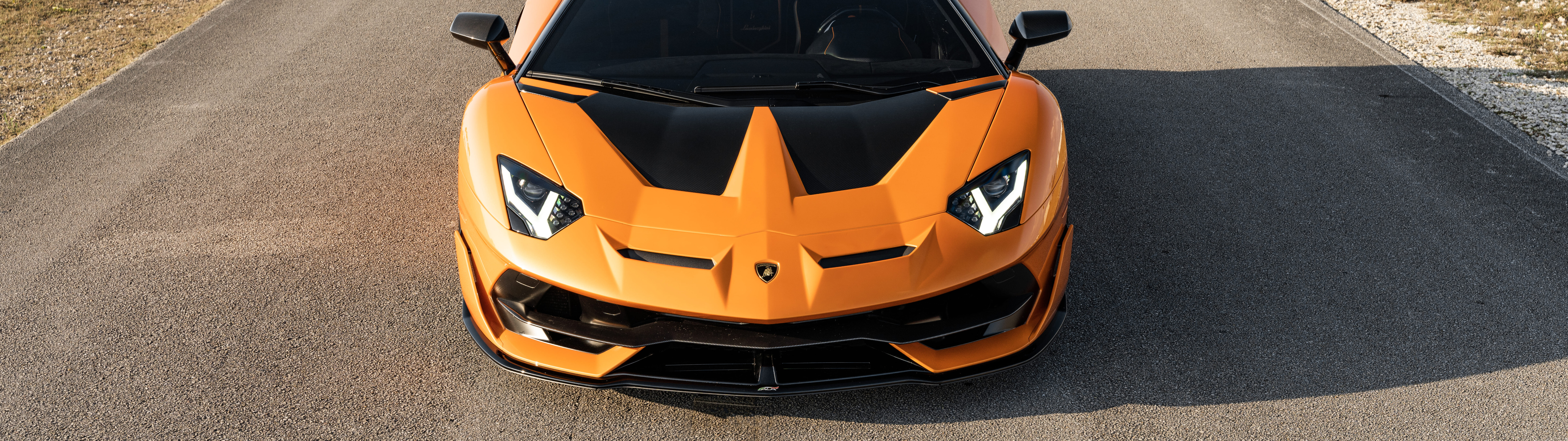 A close-up view of a Lamborghini Aventador SVJ, featuring its sleek aerodynamic bodywork and powerful supercar silhouette.