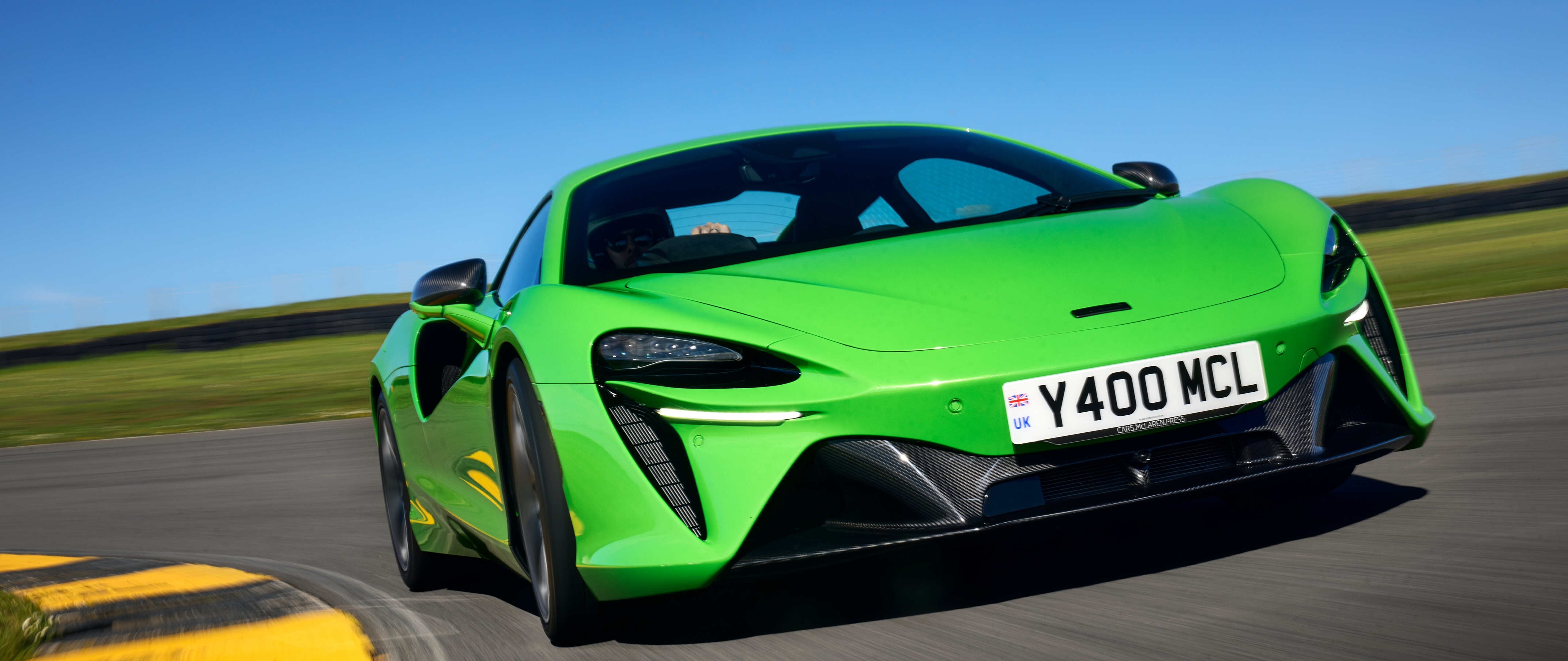 A bright green McLaren Artura luxury supercar featuring aerodynamic curves and a glossy finish.