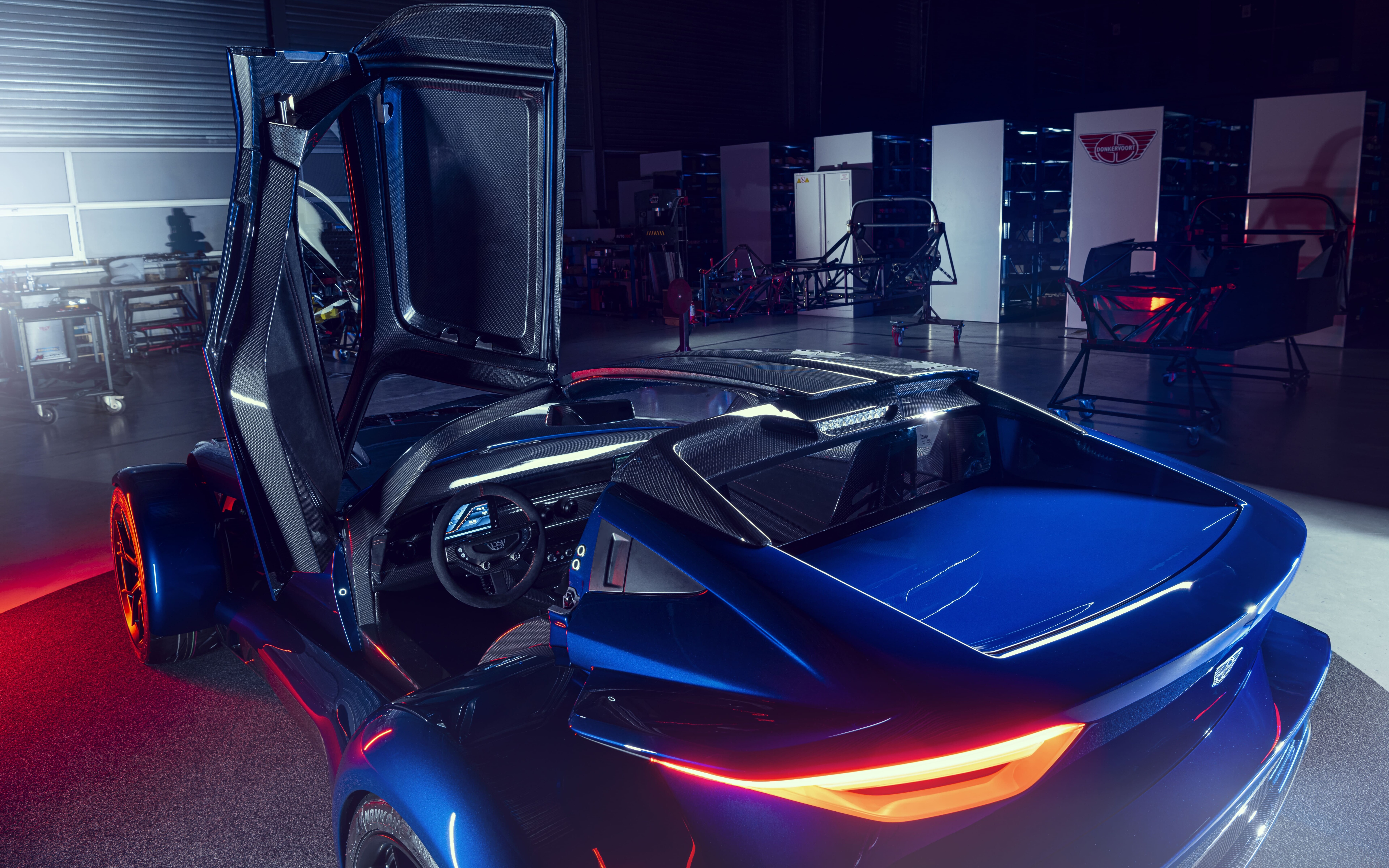 A sleek, metallic silver sports car reflecting soft studio lights against a dark background.