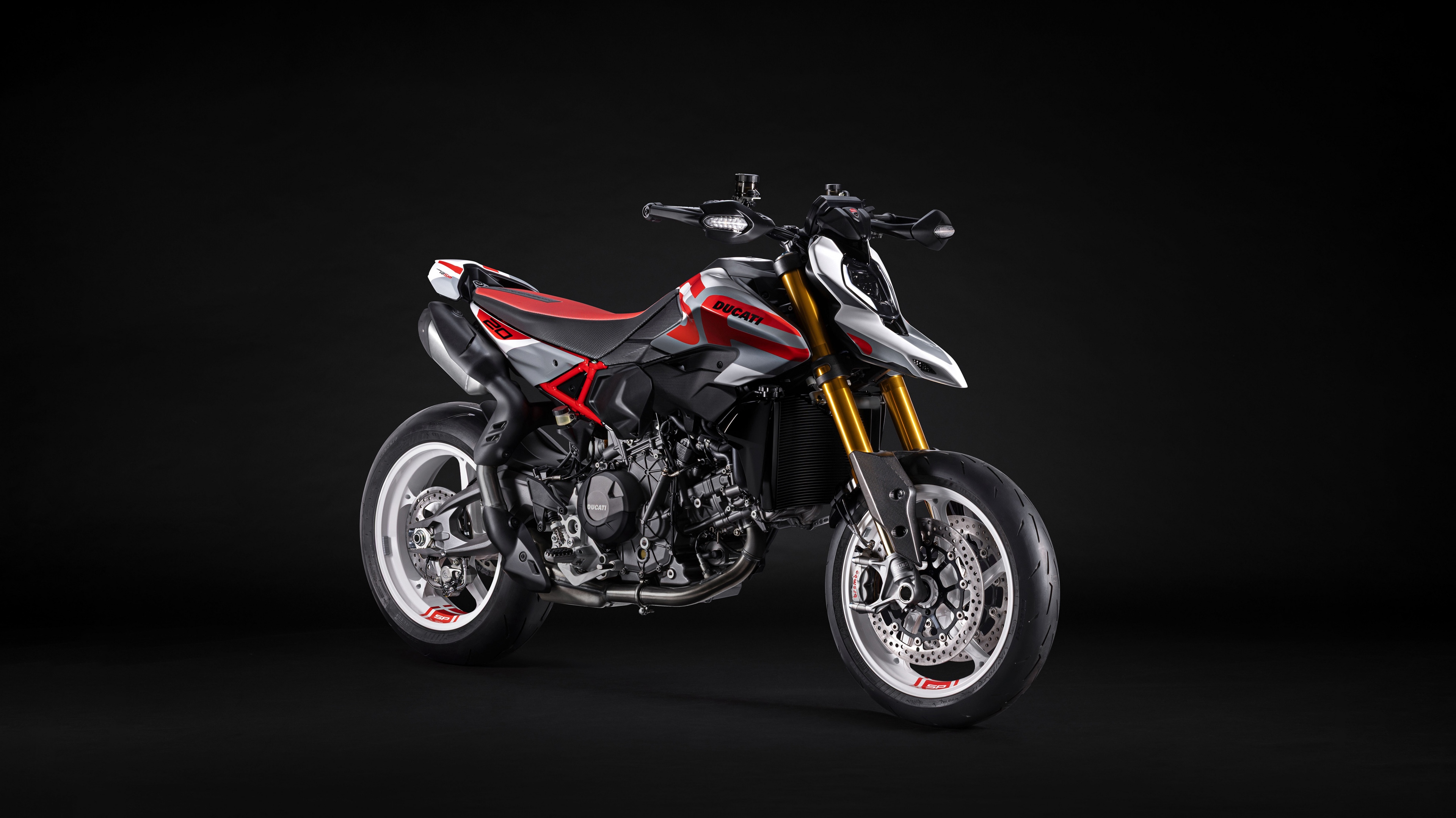 Una fotografia di alta qualità, scattata in studio, della motocicletta Ducati Hypermotard V2 del 2026, con uno sfondo scuro e minimalista.