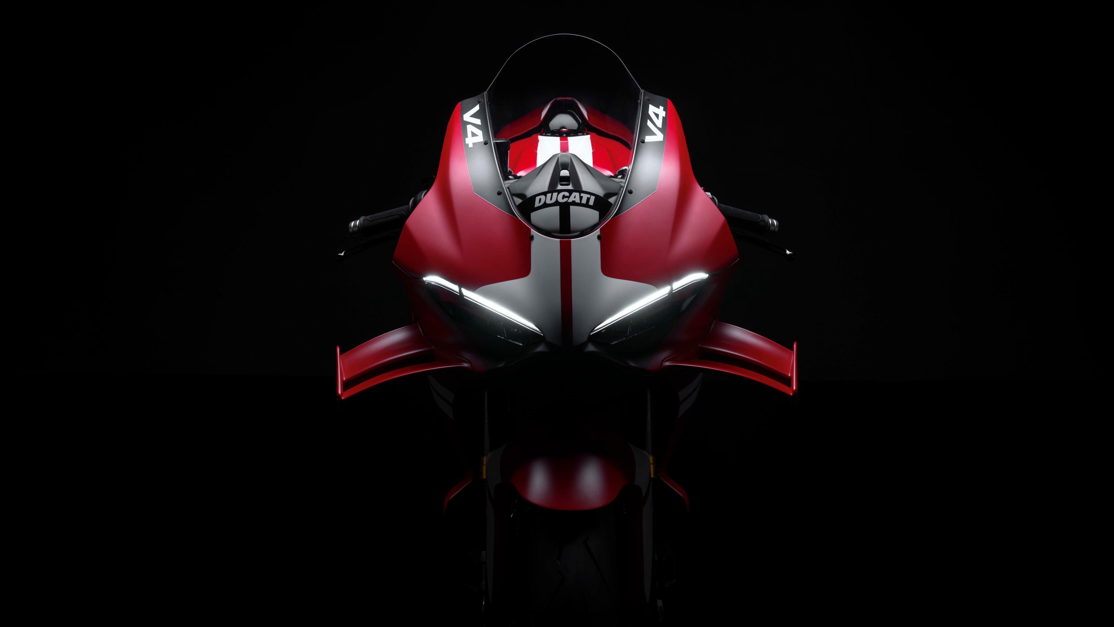 A cinematic, high-detail close-up of the Ducati Superleggera V4 Centenario motorcycle against a dark, moody background.