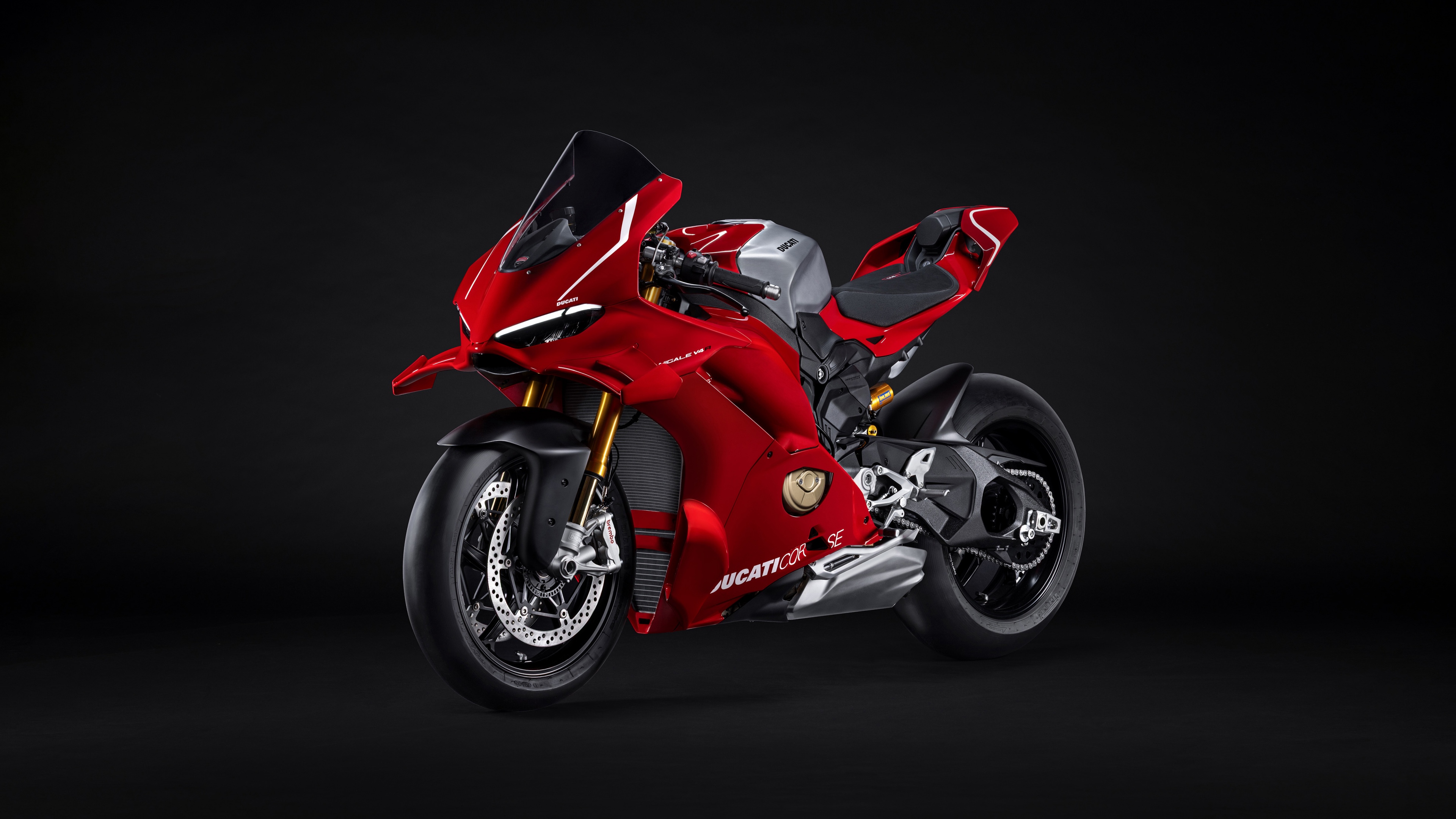 A high-resolution, close-up shot of a red Ducati Panigale V4 R sports motorcycle against a dark, minimalist background.