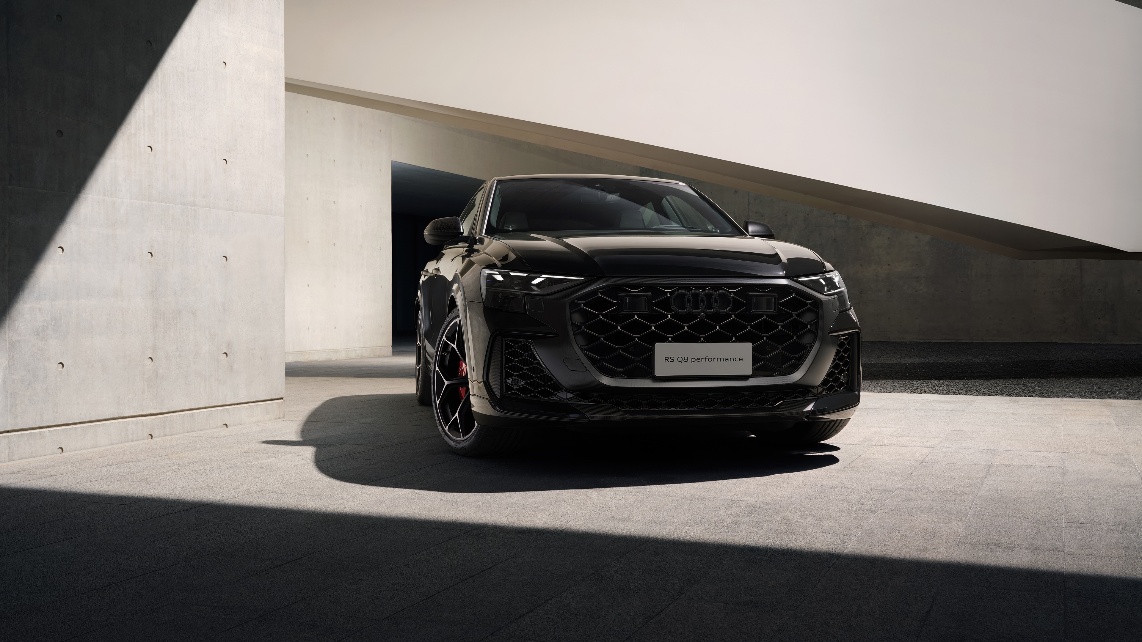 A high-resolution, cinematic shot of a black Audi RS Q8 Performance luxury SUV.