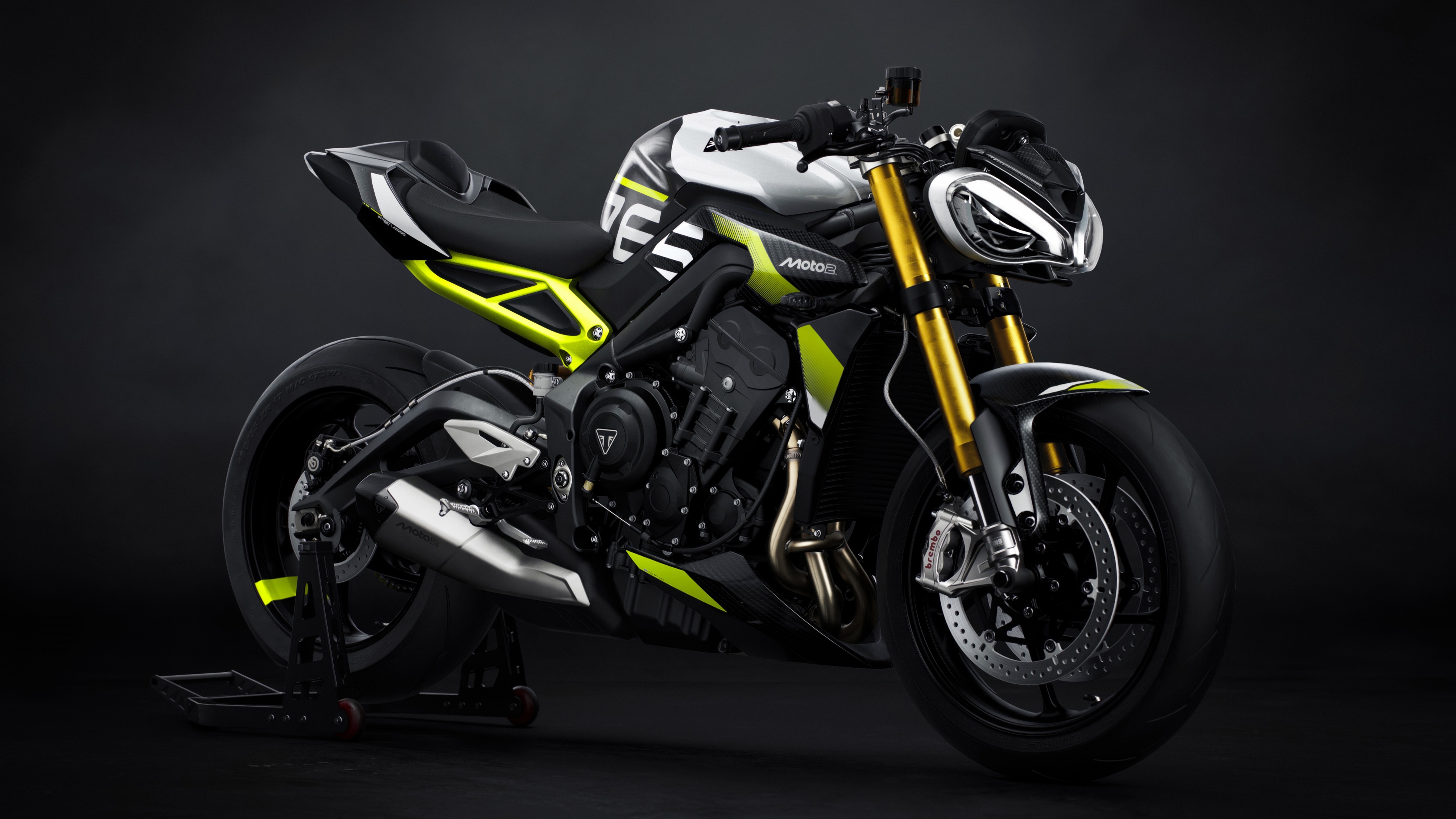 A high-resolution, close-up shot of a Triumph Street Triple 765 Moto2 Edition motorcycle against a dark, moody background.
