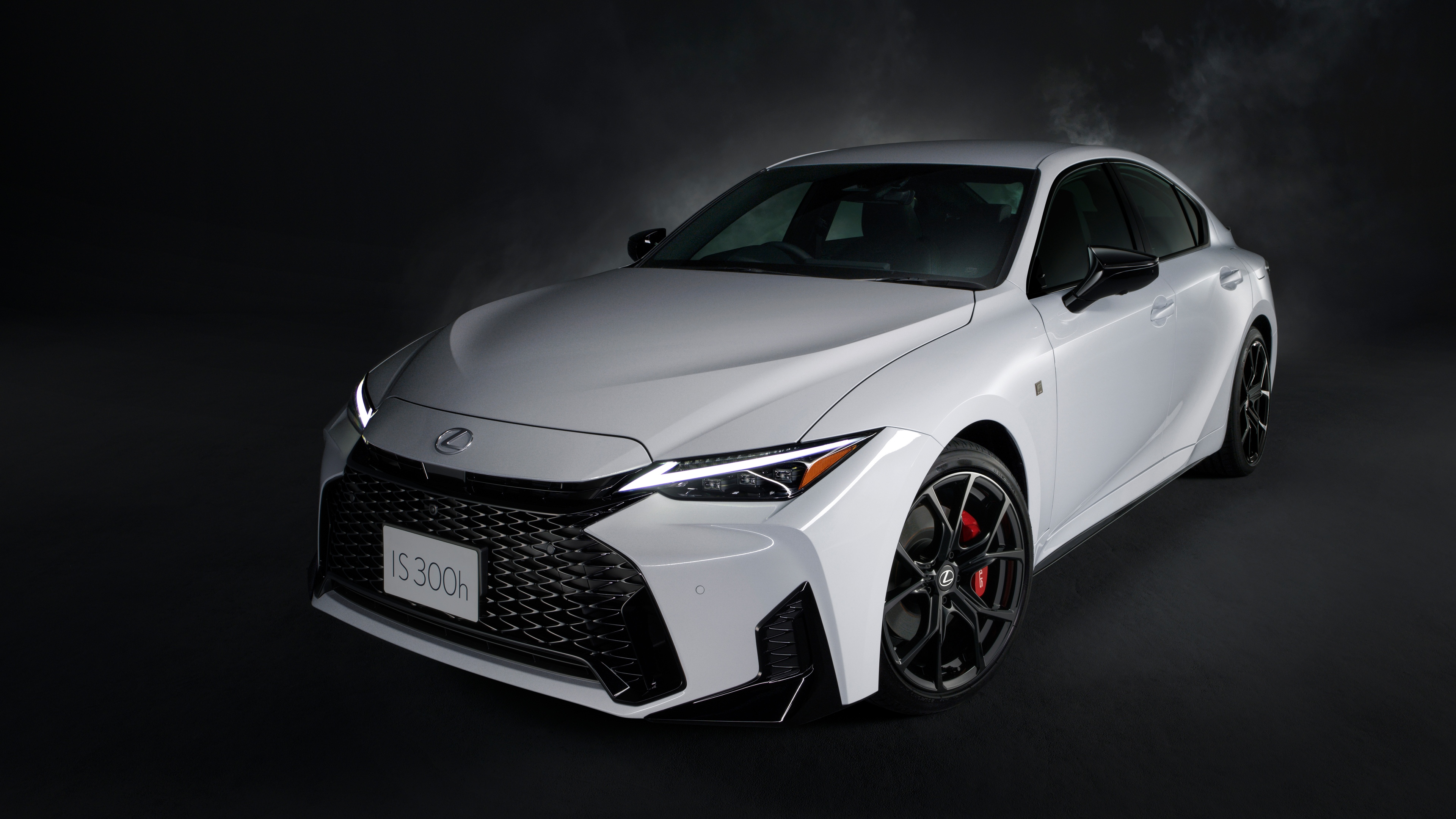 A high-resolution, cinematic shot of a 2026 Lexus IS 300h sedan against a dark, moody background.