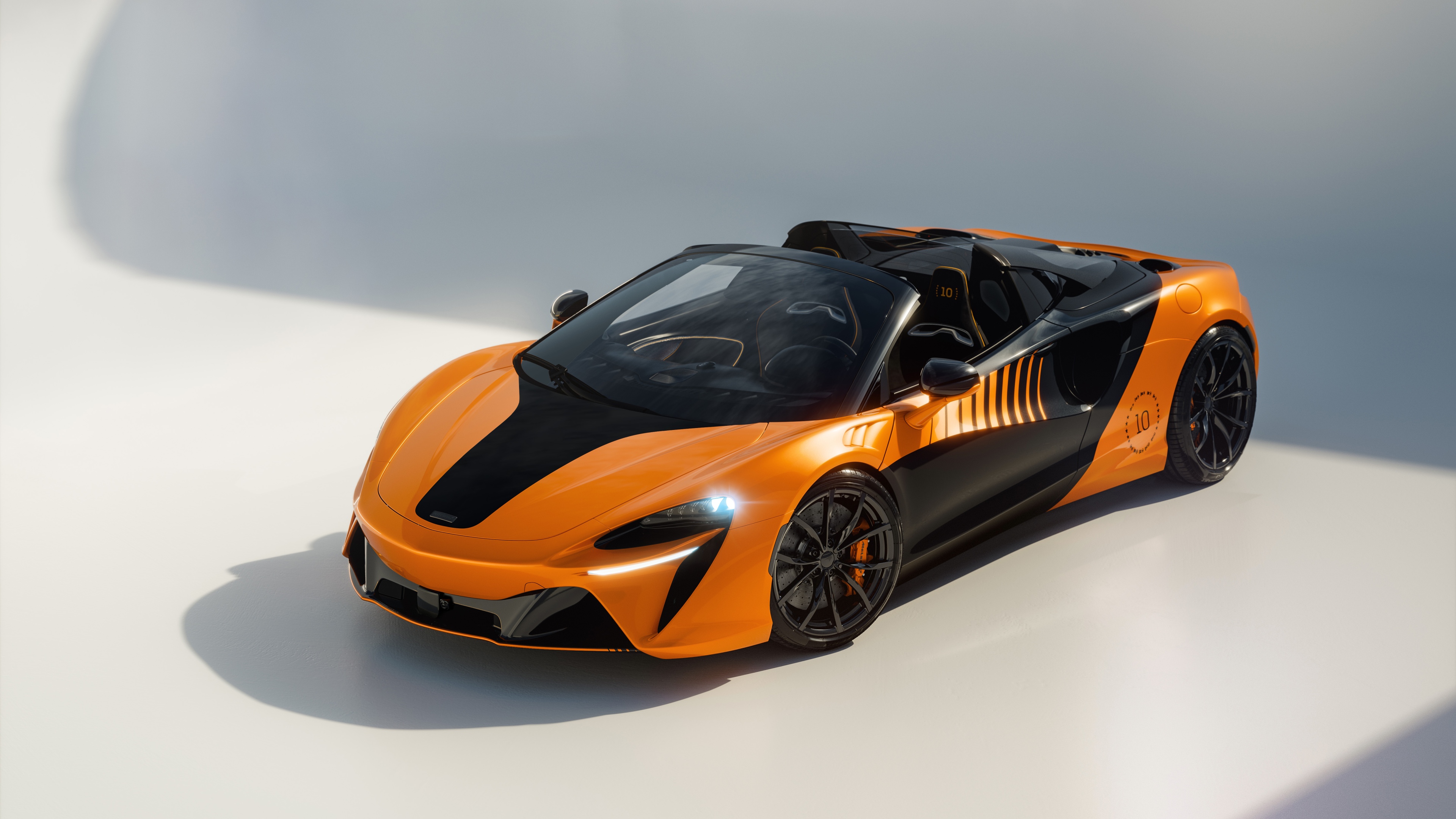 A detailed close-up of the 2026 McLaren Artura Spider Championship Edition hybrid supercar, featuring premium finishes and aerodynamic styling.