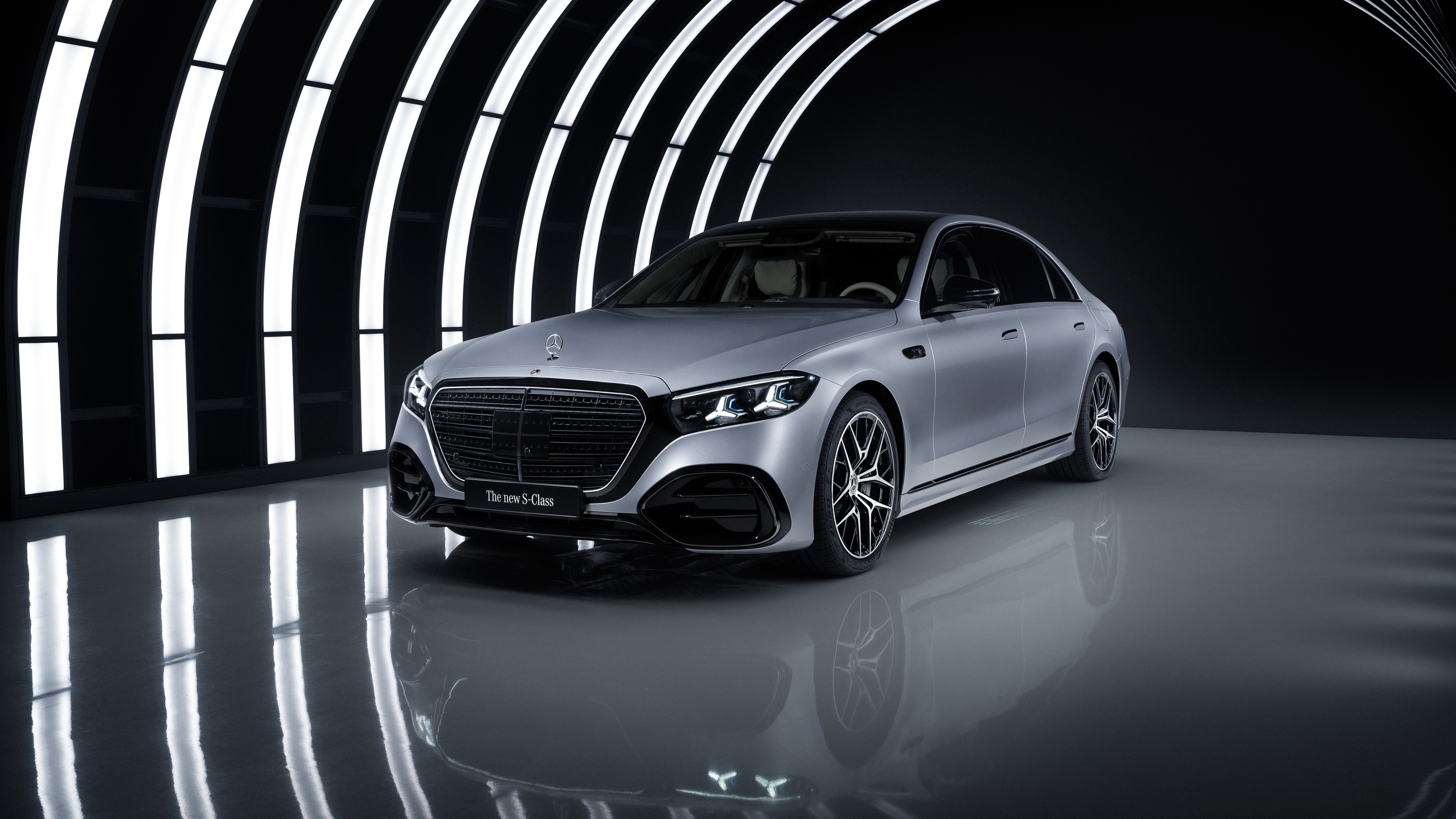 A luxury 2026 Mercedes-Benz S 580 e 4MATIC AMG line sedan captured in a dark, cinematic setting with glowing LED highlights.
