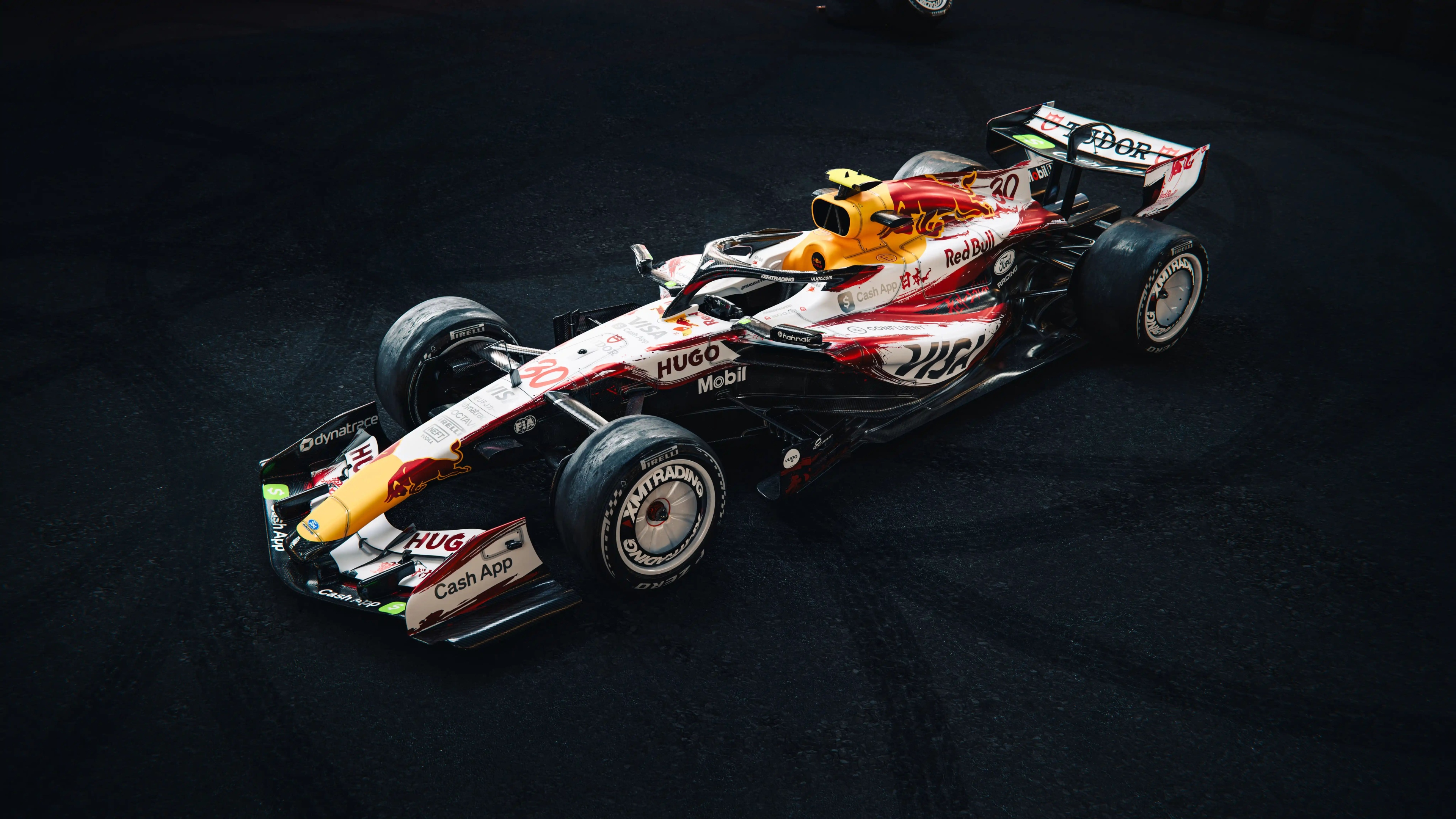 The Racing Bulls VCARB 03 Formula One car at the Japanese Grand Prix, featuring a dark and moody atmosphere.