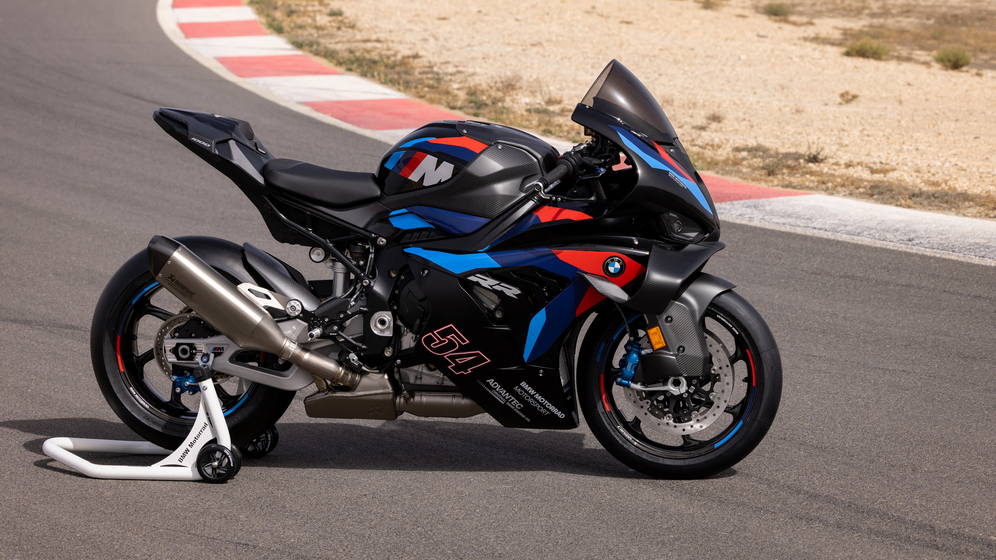 A BMW M 1000 RR sports motorcycle parked on a clean asphalt road