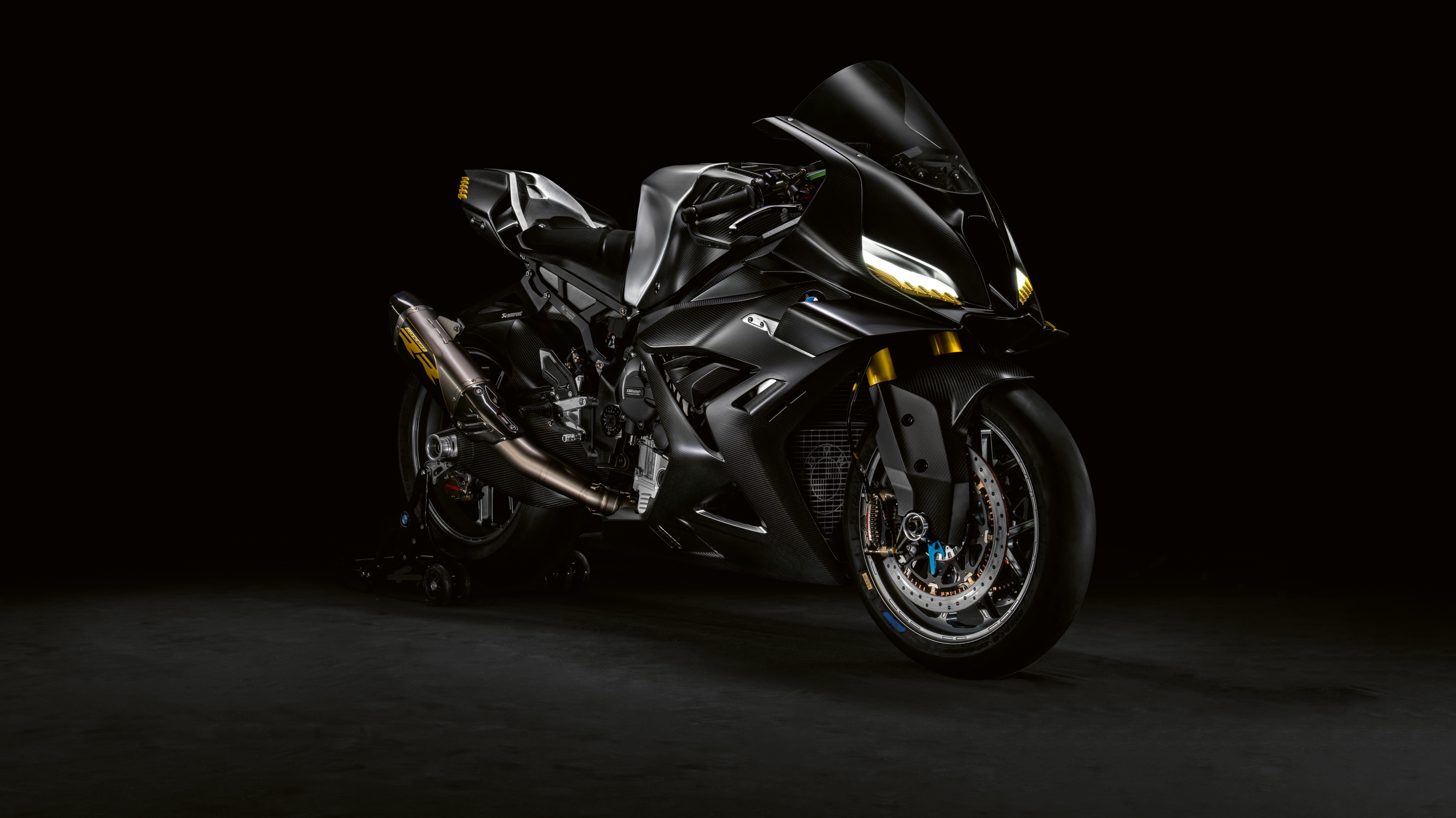 A futuristic BMW Motorrad Concept RR motorcycle with a dark, sleek design against a black background.