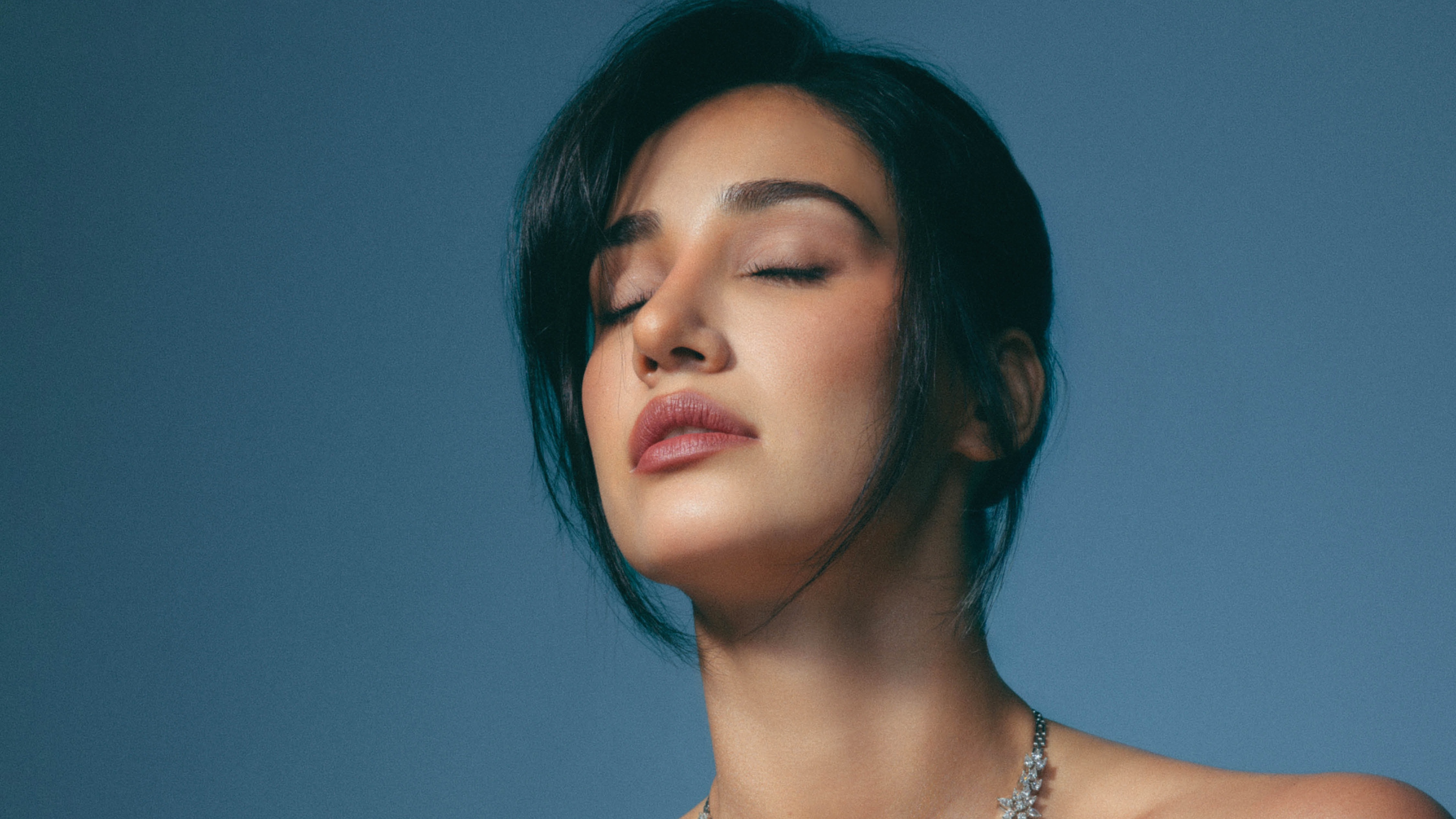 A vertical portrait of Indian actress Disha Patani wearing a sophisticated and luxurious necklace.