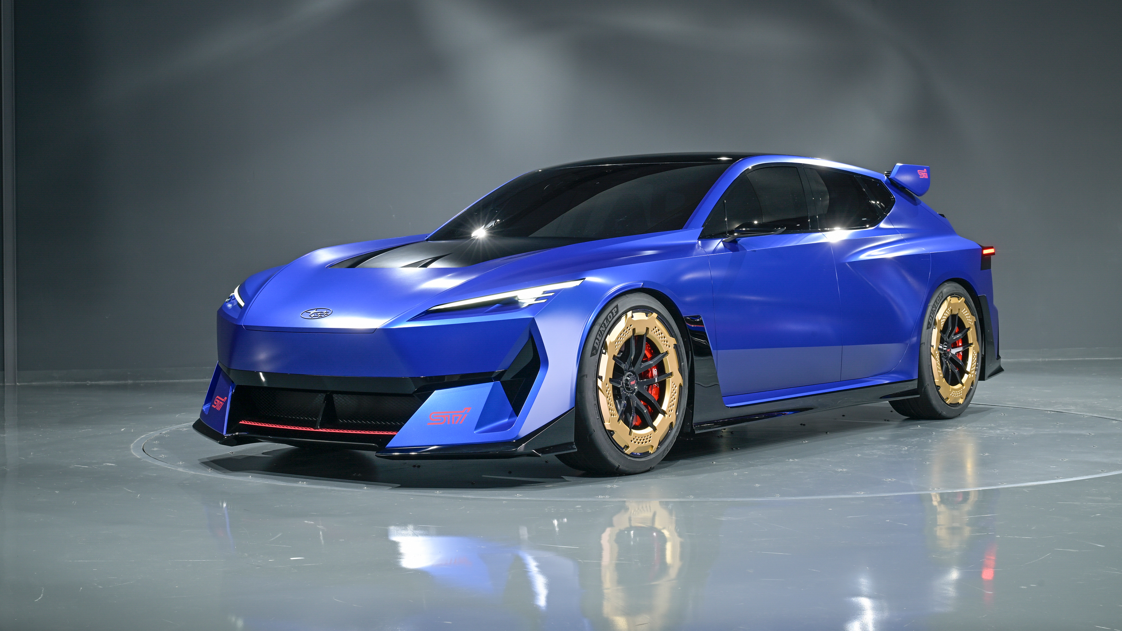 A sleek 2025 electric rally car with glowing blue accents and futuristic design racing through a dusty, rugged landscape.