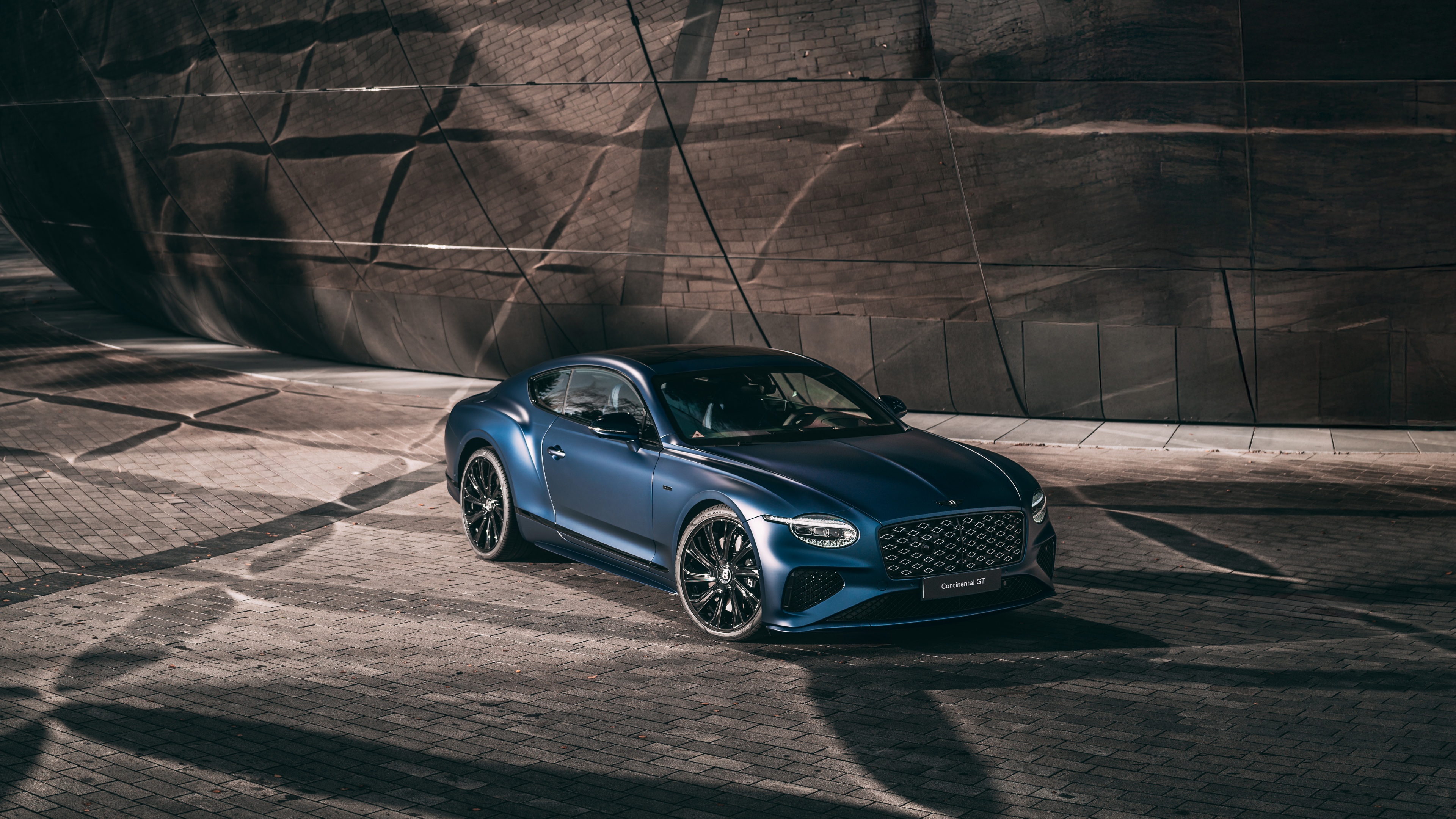 A sleek and futuristic Bentley Continental GT featuring advanced LED lighting and aerodynamic metallic bodywork.