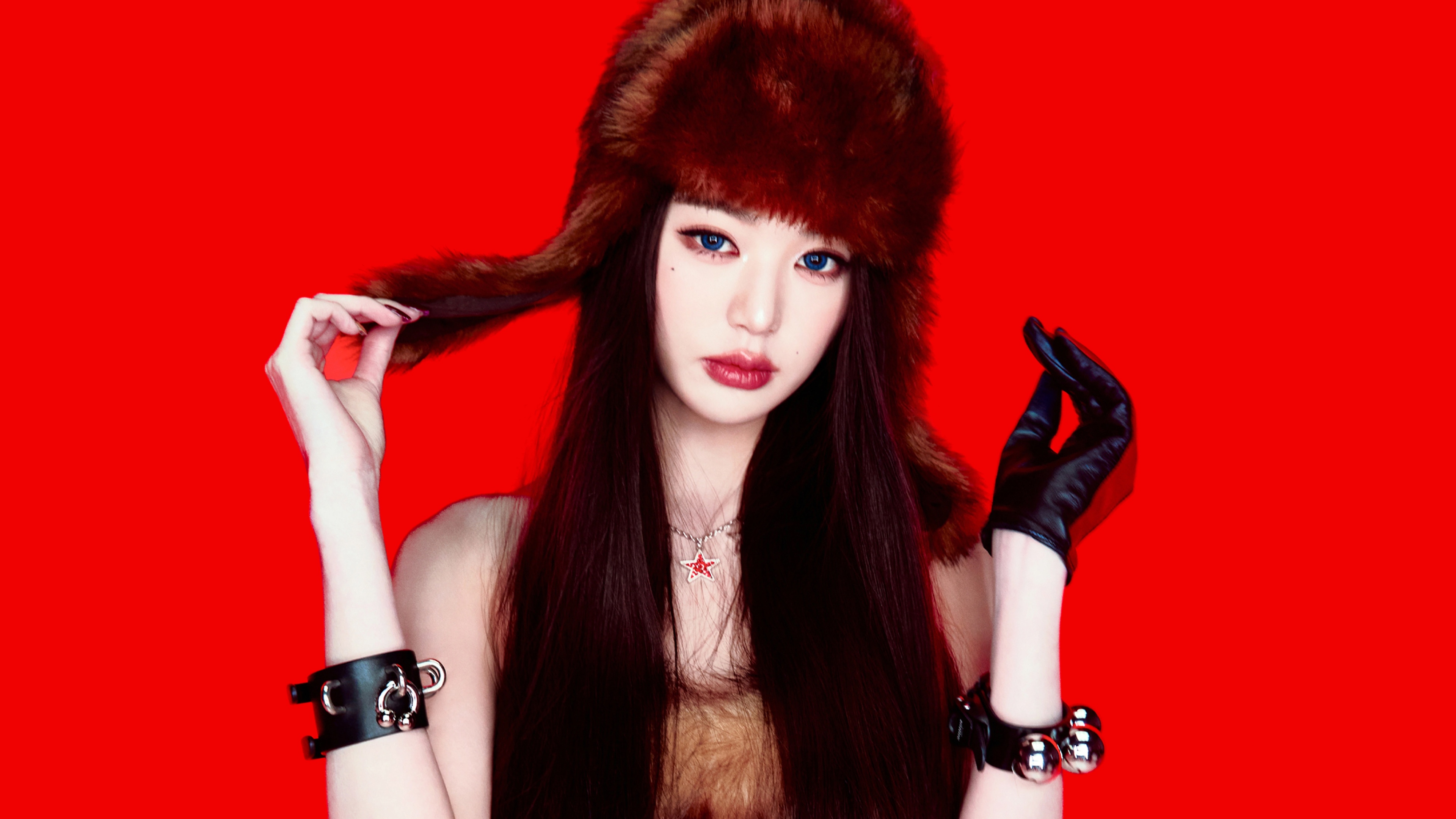 Close-up portrait of Jang Wonyoung from IVE with blue eyes and a red background
