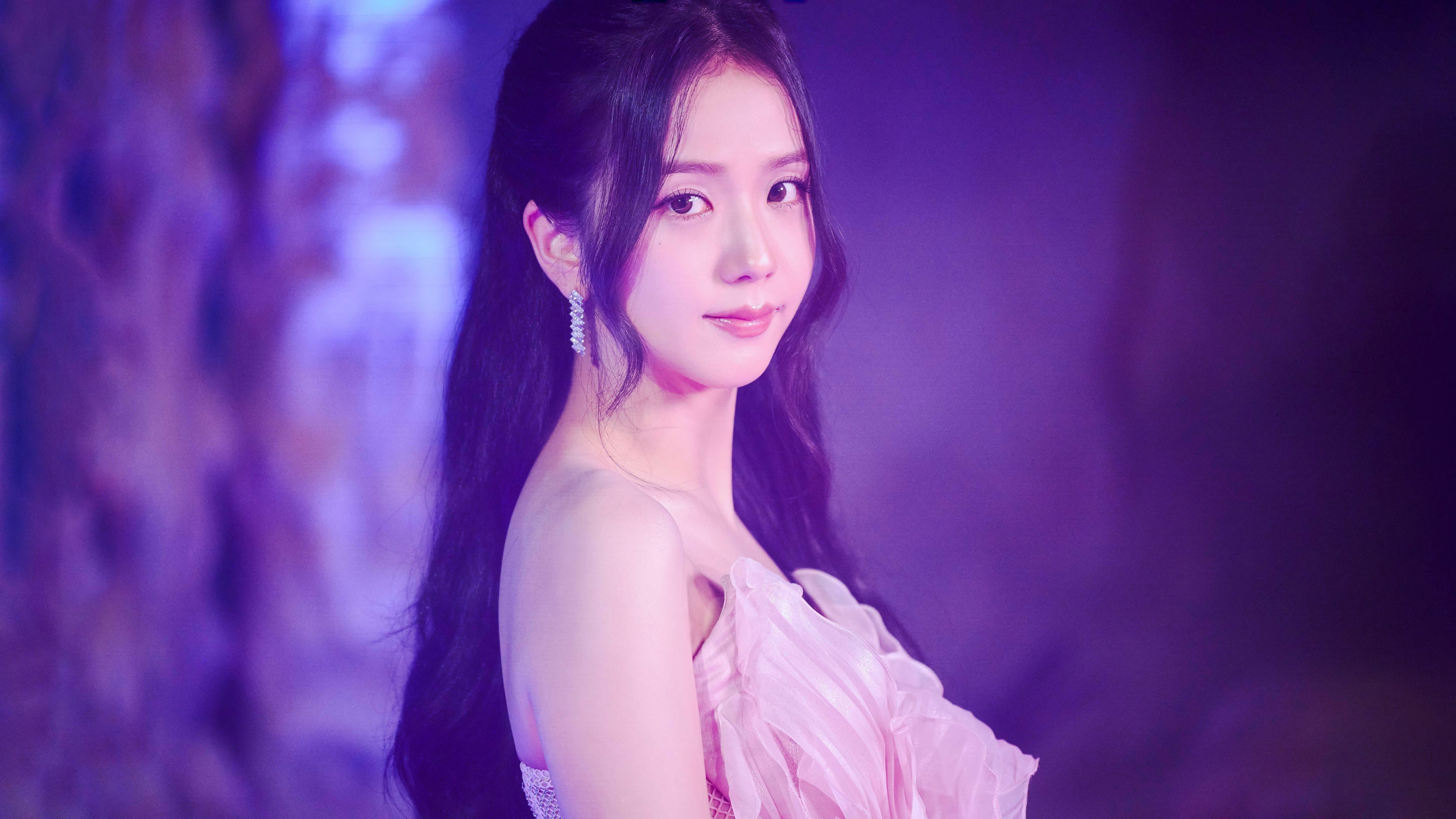 A portrait of Jisoo from BLACKPINK wearing a pink dress against a dreamy purple aesthetic background.