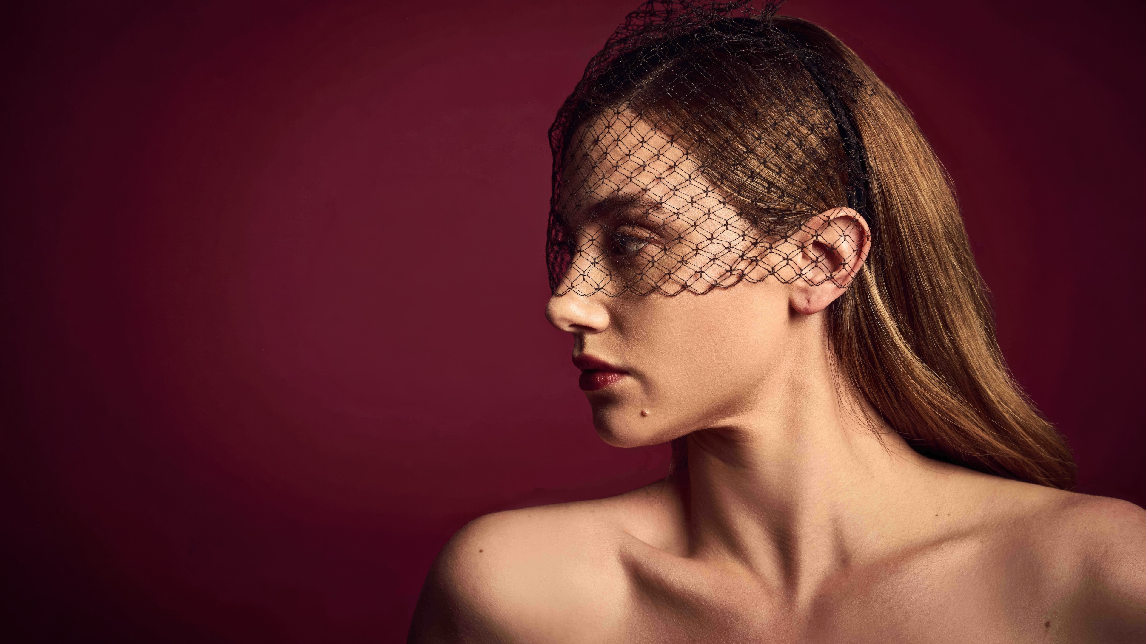 A professional portrait of Lili Reinhart set against a vibrant, solid red background in a magazine editorial style.
