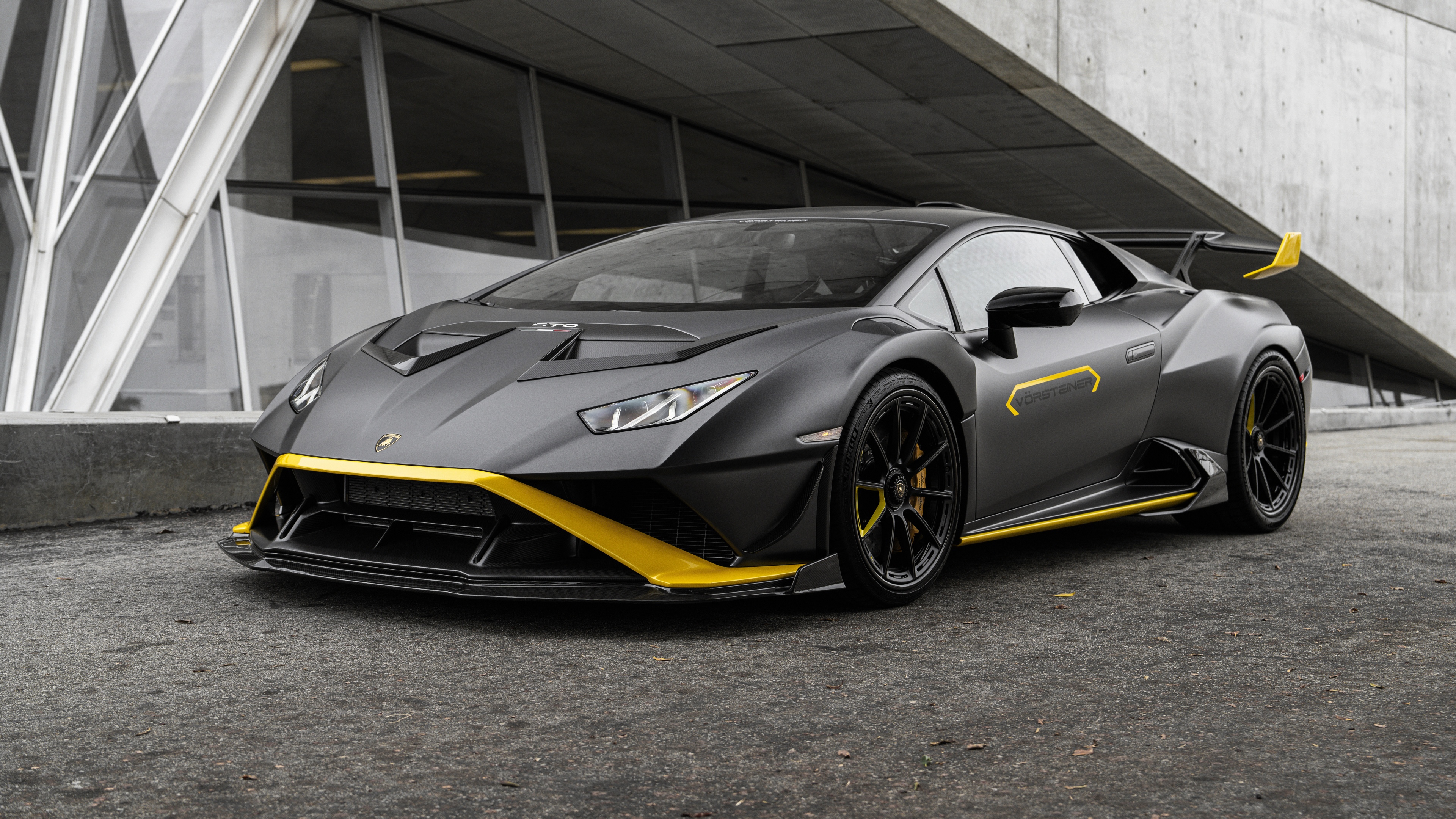 A high-resolution close-up of a matte black Lamborghini Huracán STO supercar featuring aggressive aerodynamic styling.