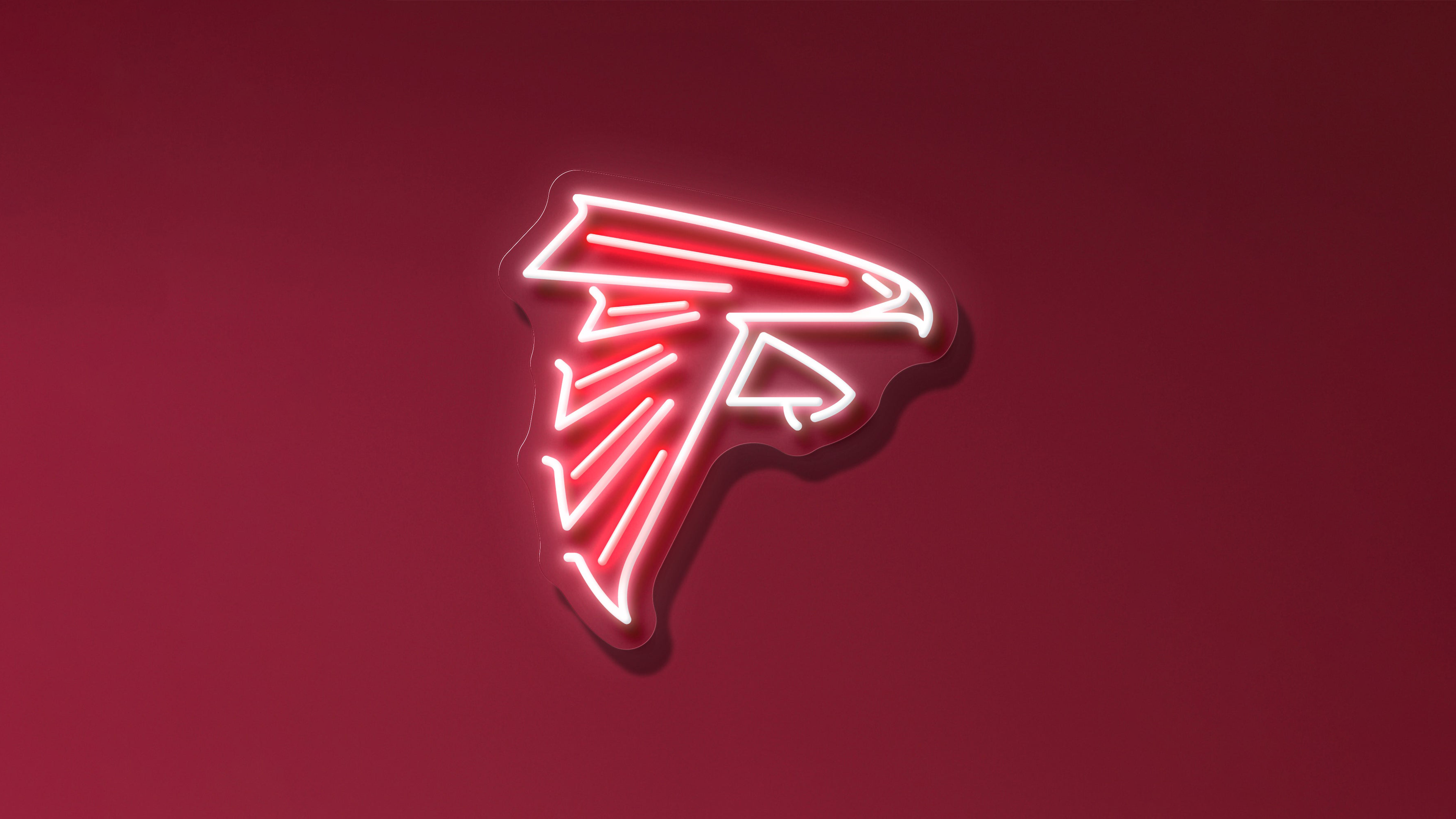 A glowing neon Atlanta Falcons logo centered on a solid red background.