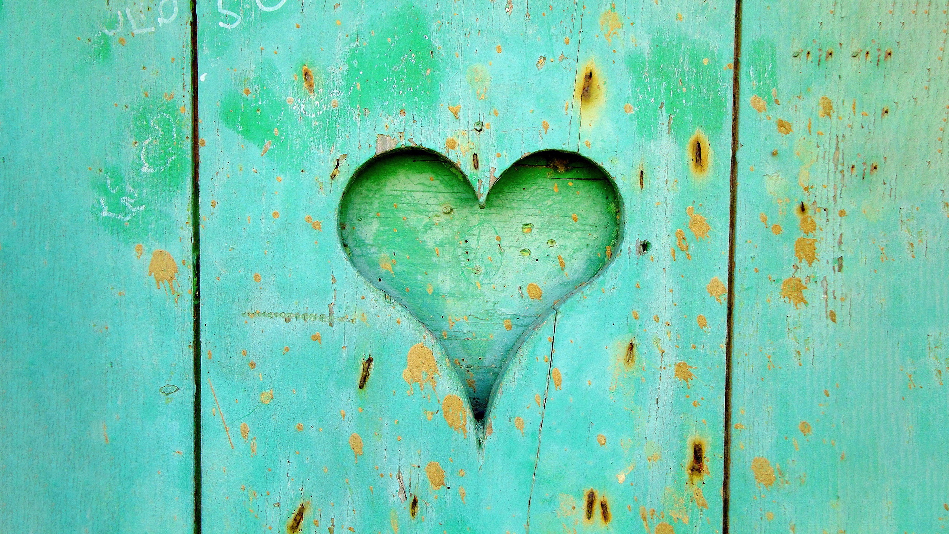 A pastel cyan heart resting on a rustic wooden background.