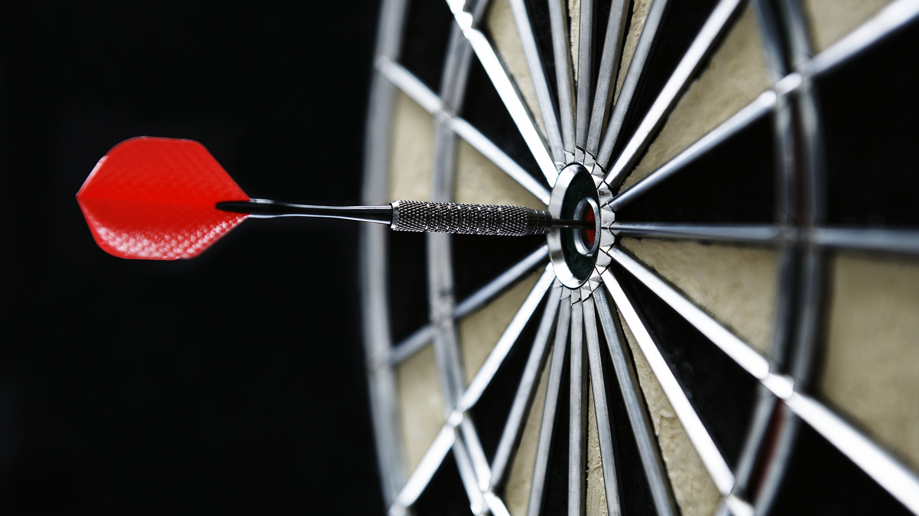 A vivid red and white bullseye target centered on a stark, pitch-black background.