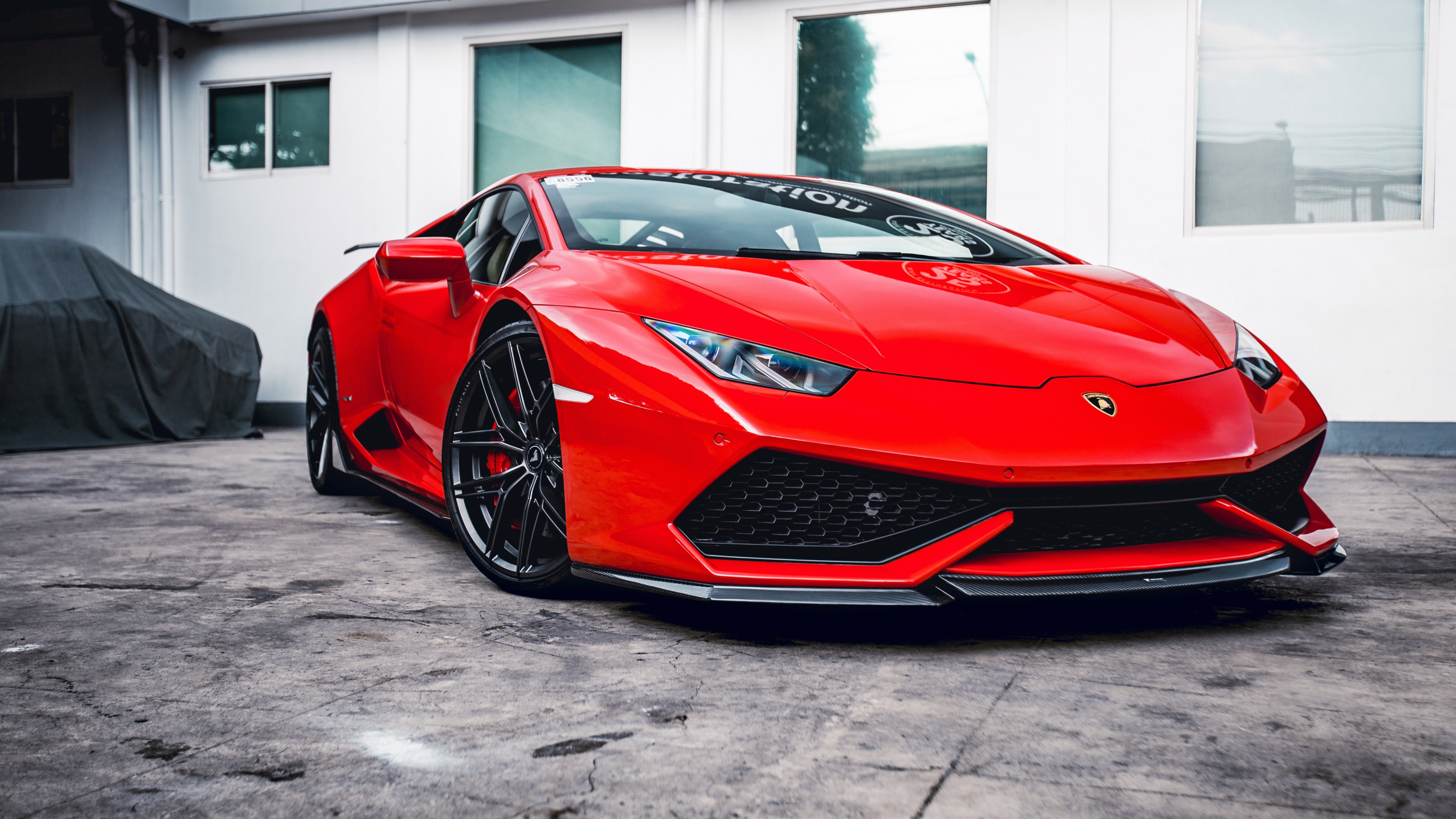 A detailed view of a red Lamborghini Huracan with Vorsteiner performance parts and widebody kit.