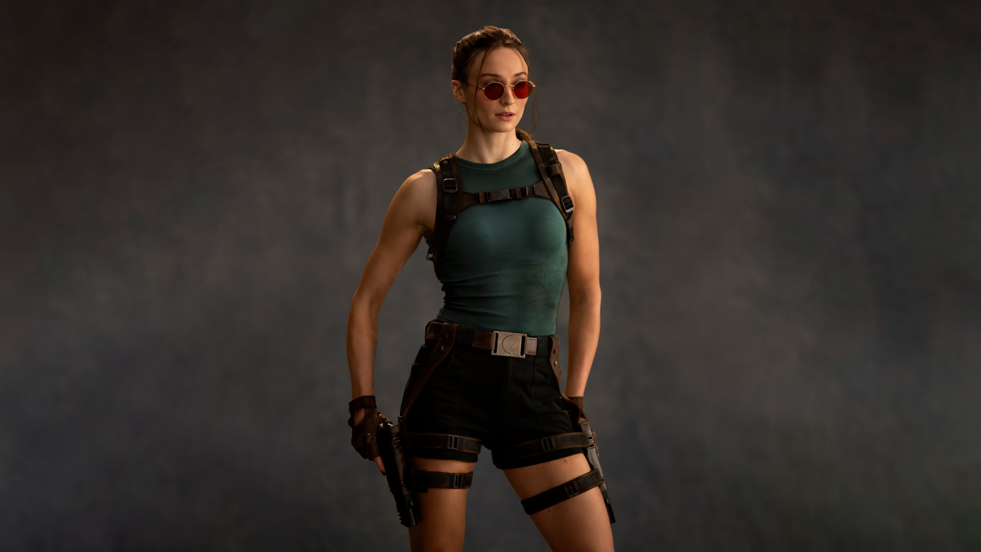 Sophie Turner portraying the character Lara Croft from the Tomb Raider franchise in a cinematic setting.