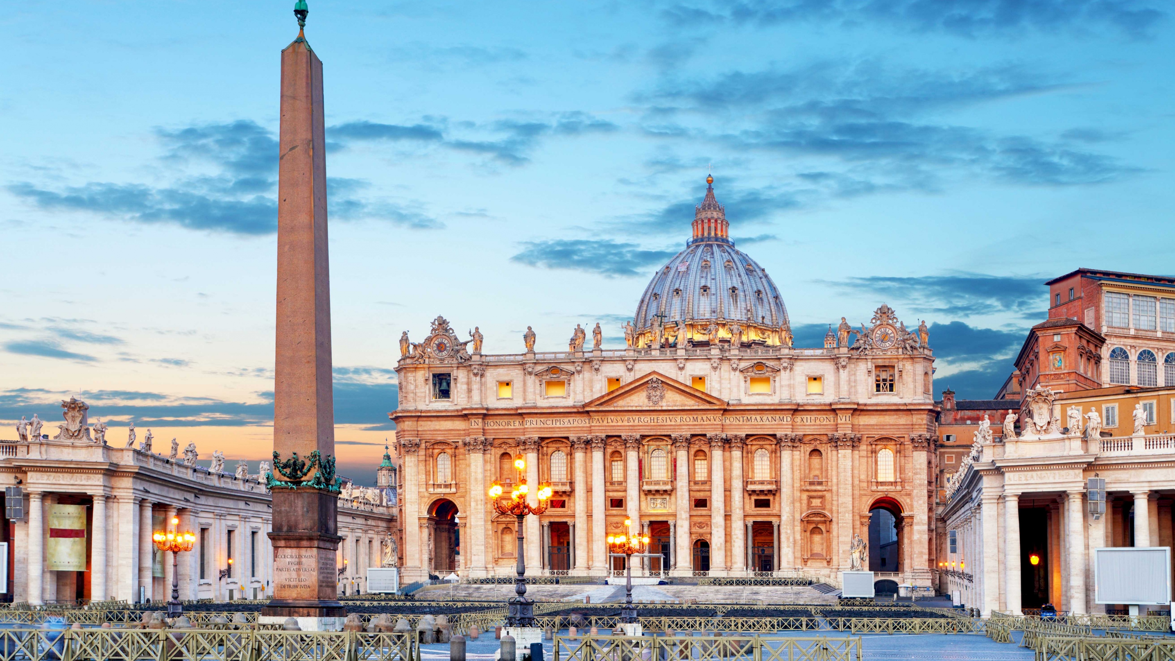 A majestic historical church silhouetted against a vibrant sunset sky at dusk.
