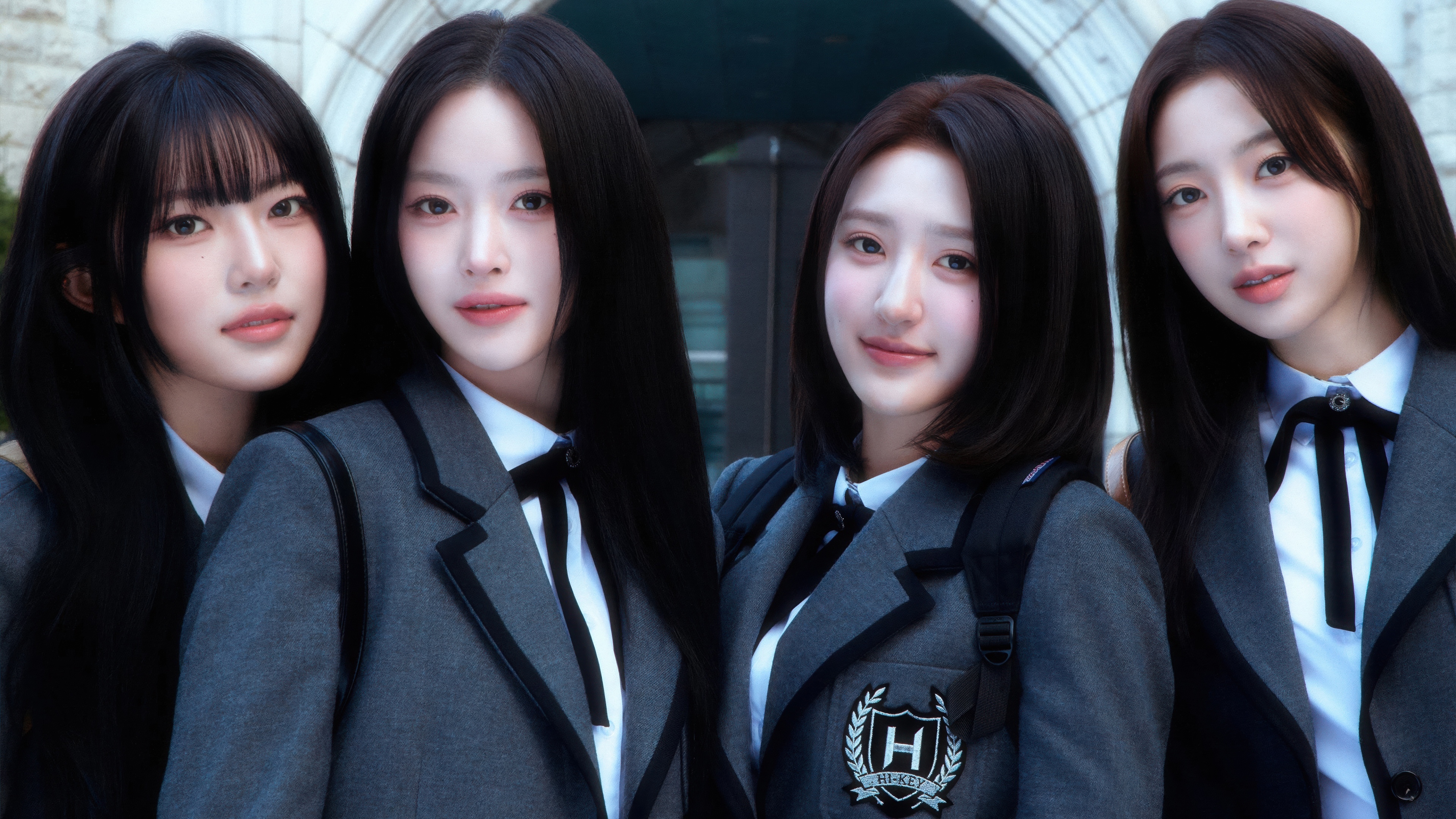 A group of young women in futuristic metallic and neon-accented clothing, representing a 2026 girl group concept.