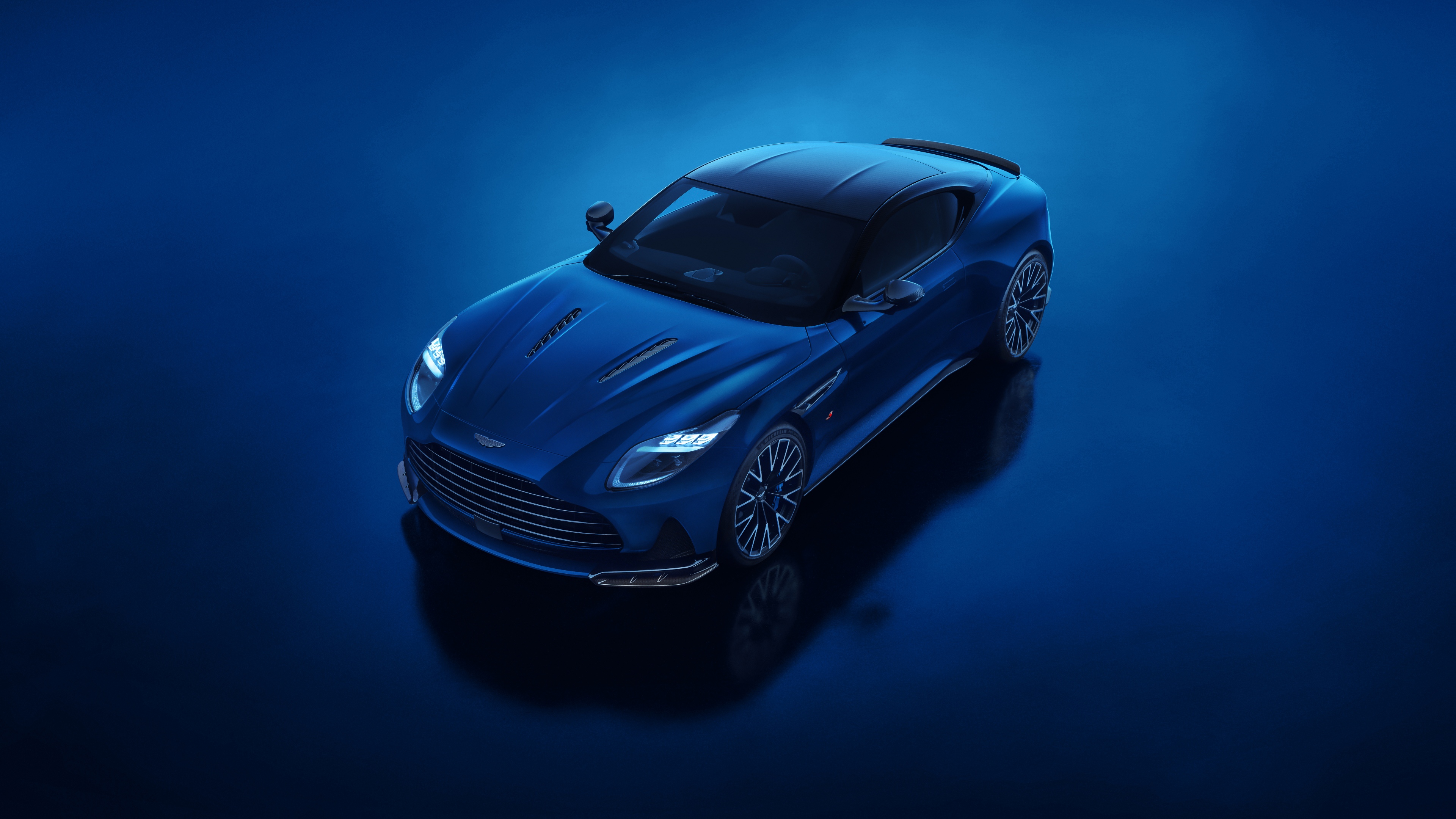 A high-resolution, sleek blue 2025 Aston Martin DB12 S super tourer with a vibrant blue aesthetic.