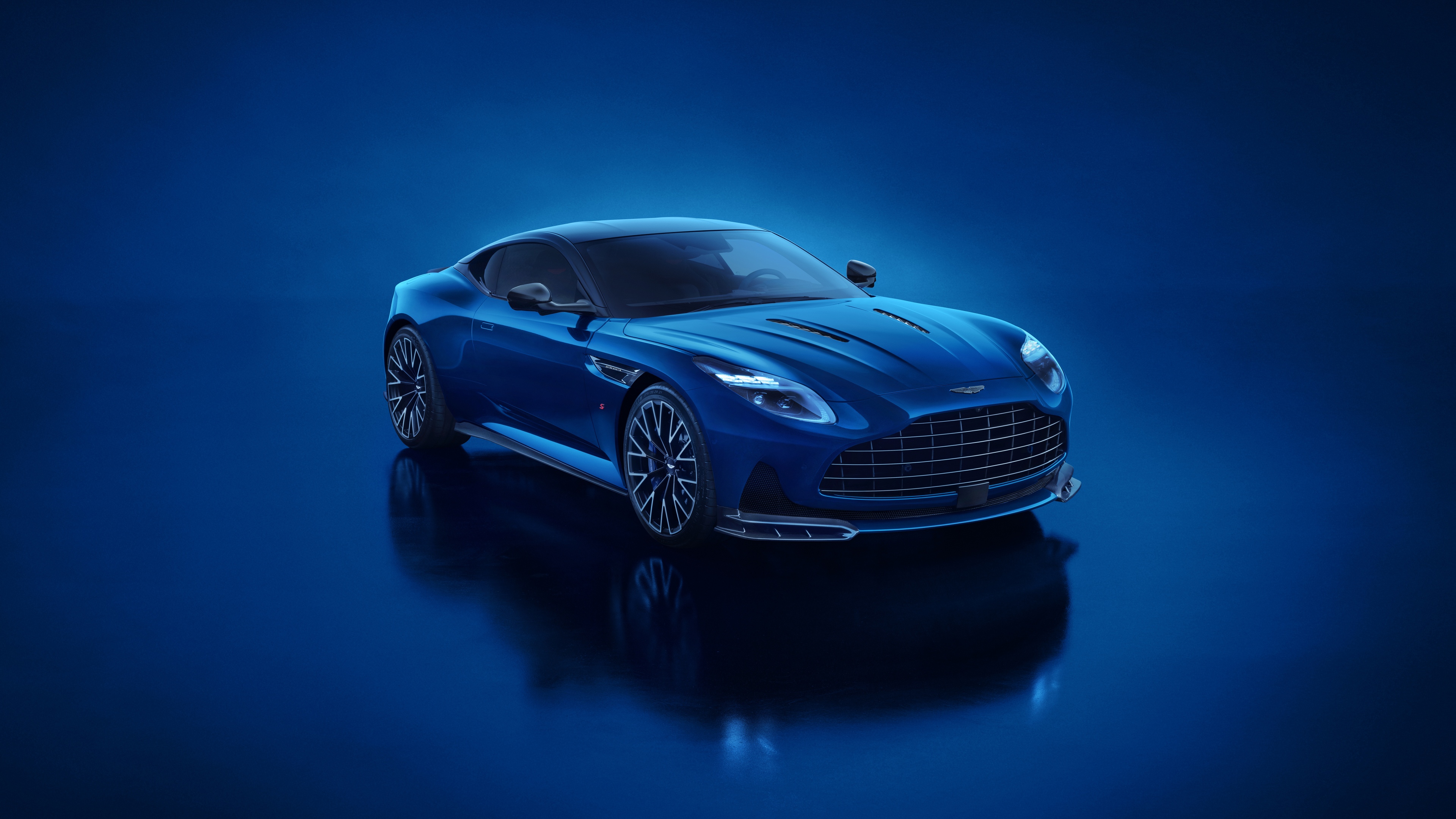 A high-resolution shot of a blue 2025 Aston Martin DB12 S luxury super tourer with a striking blue aesthetic.