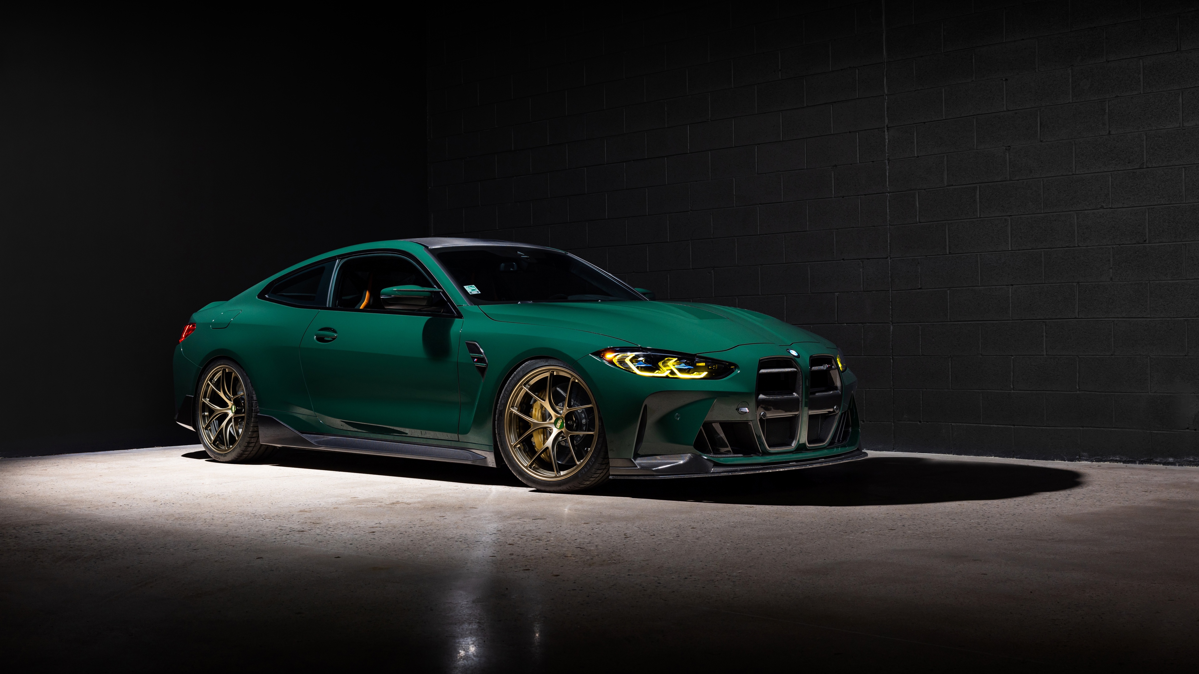 A high-resolution shot of a BMW M4 Coupe against a dark, minimalist background.