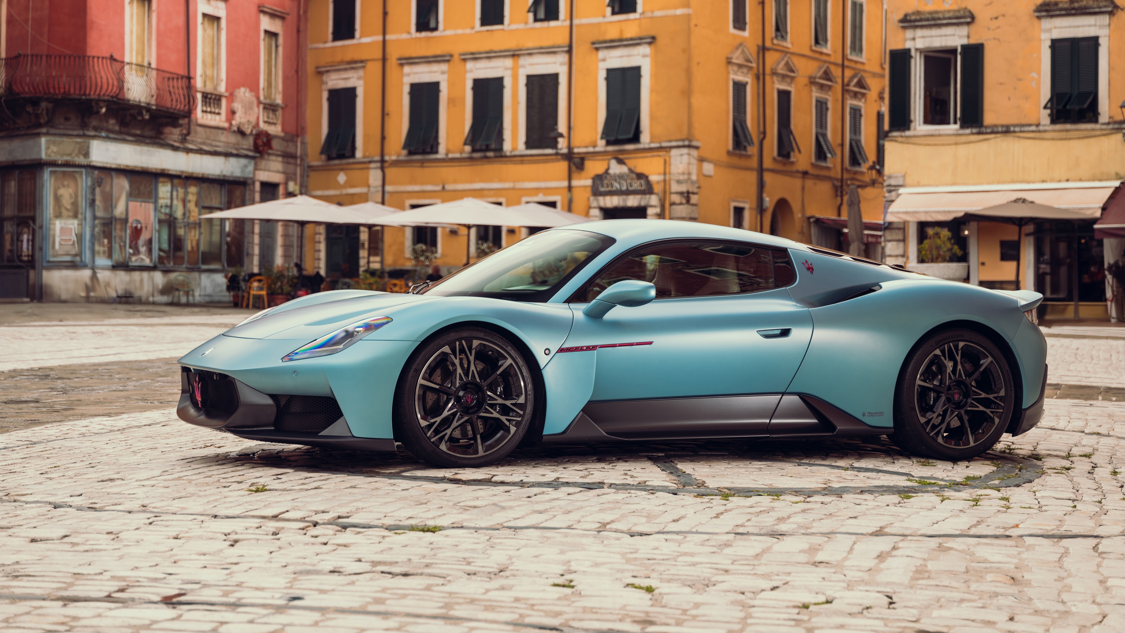 A futuristic Maserati MCPURA 2025 supercar parked in a scenic outdoor environment.
